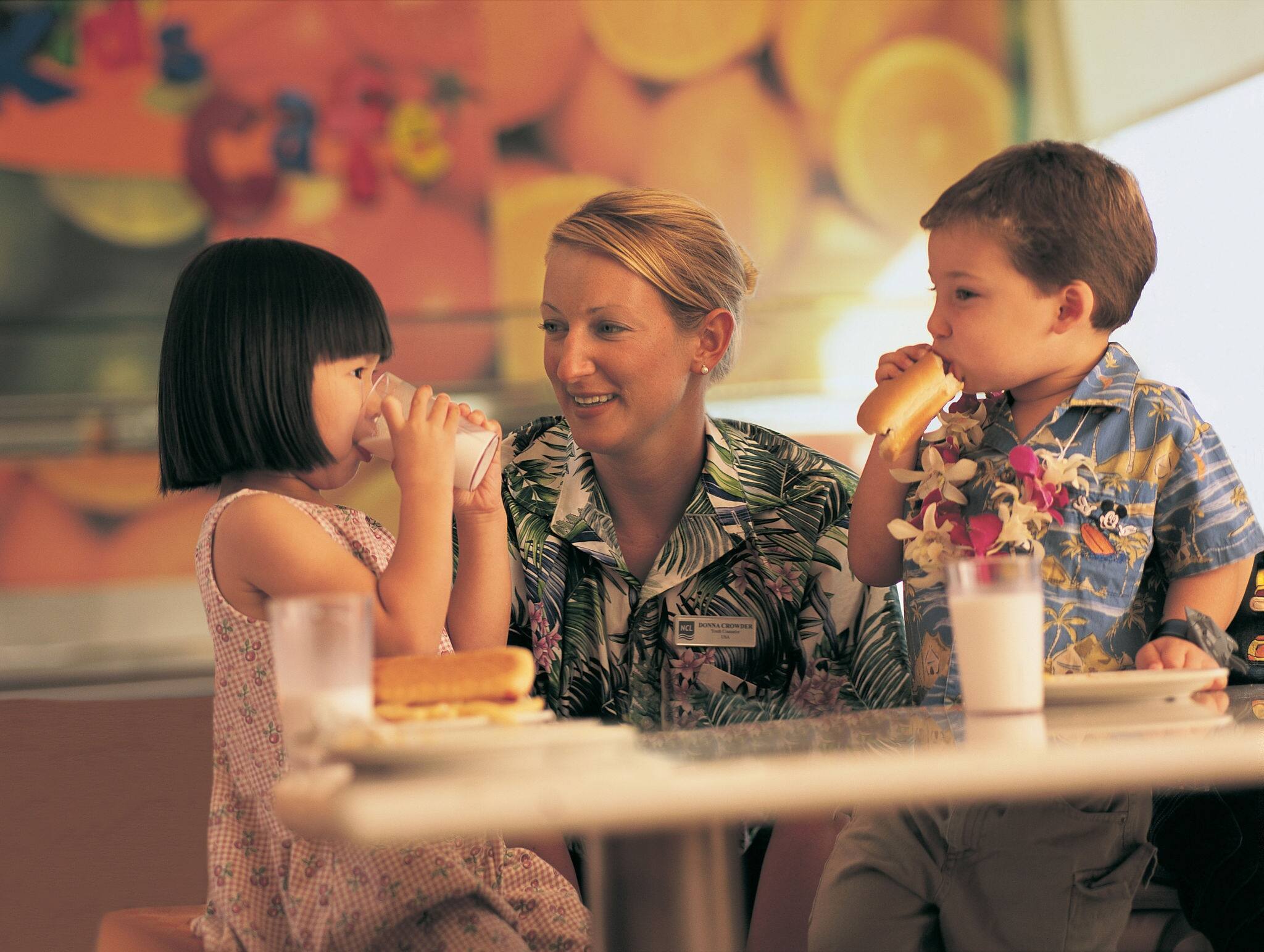 Kids enjoying hot dogs in the Kids Cafe