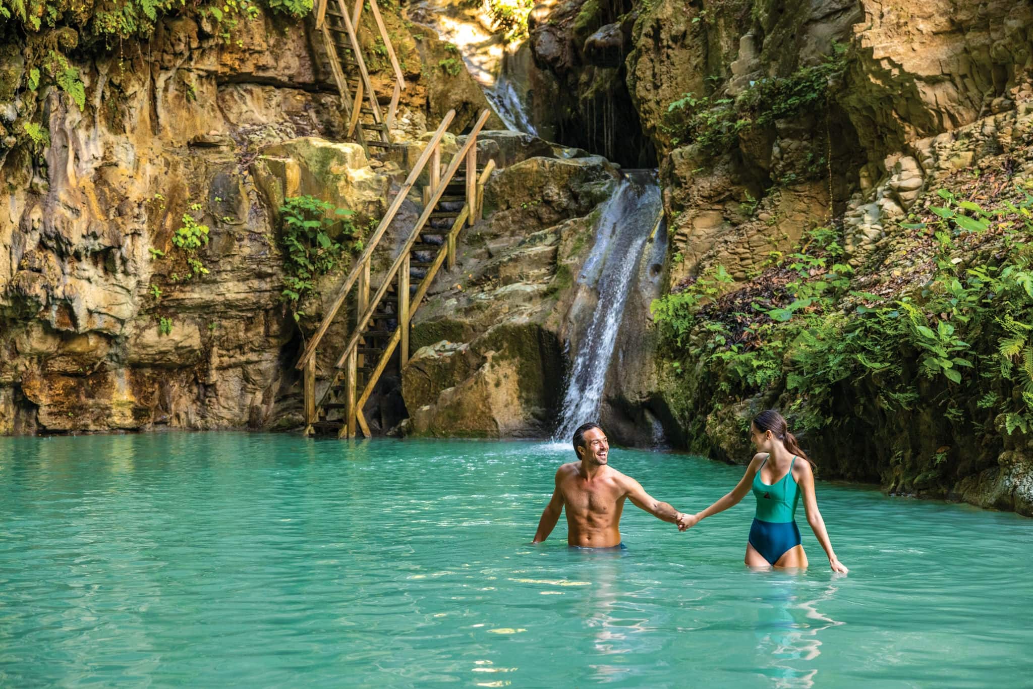 couple holding hands in turquoise waters