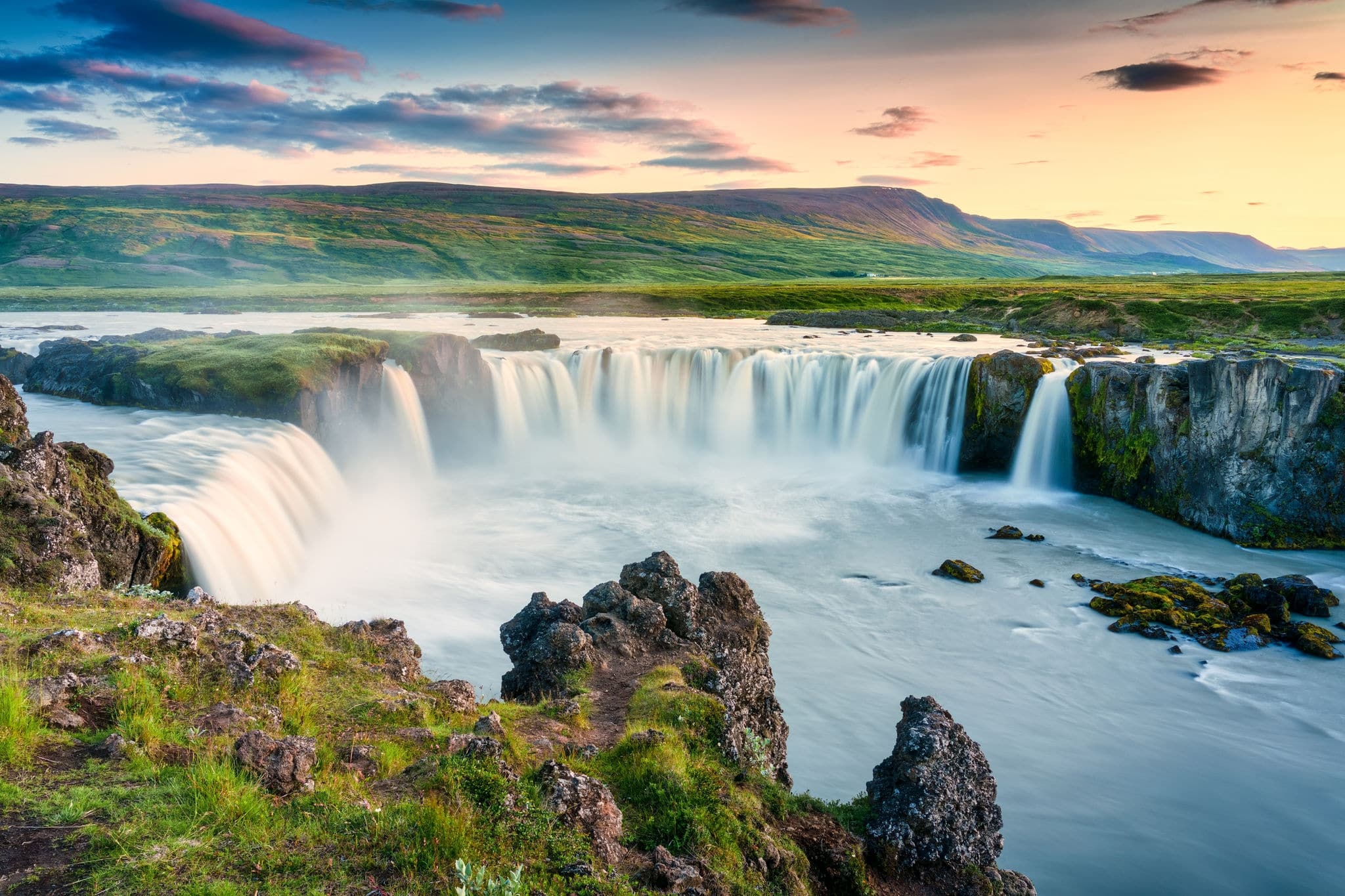 Majestic landscape of Godafoss waterfall or waterfall of the gods flowing and colorful sunset sky on Skjalfandafljot river in summer at Northern Iceland