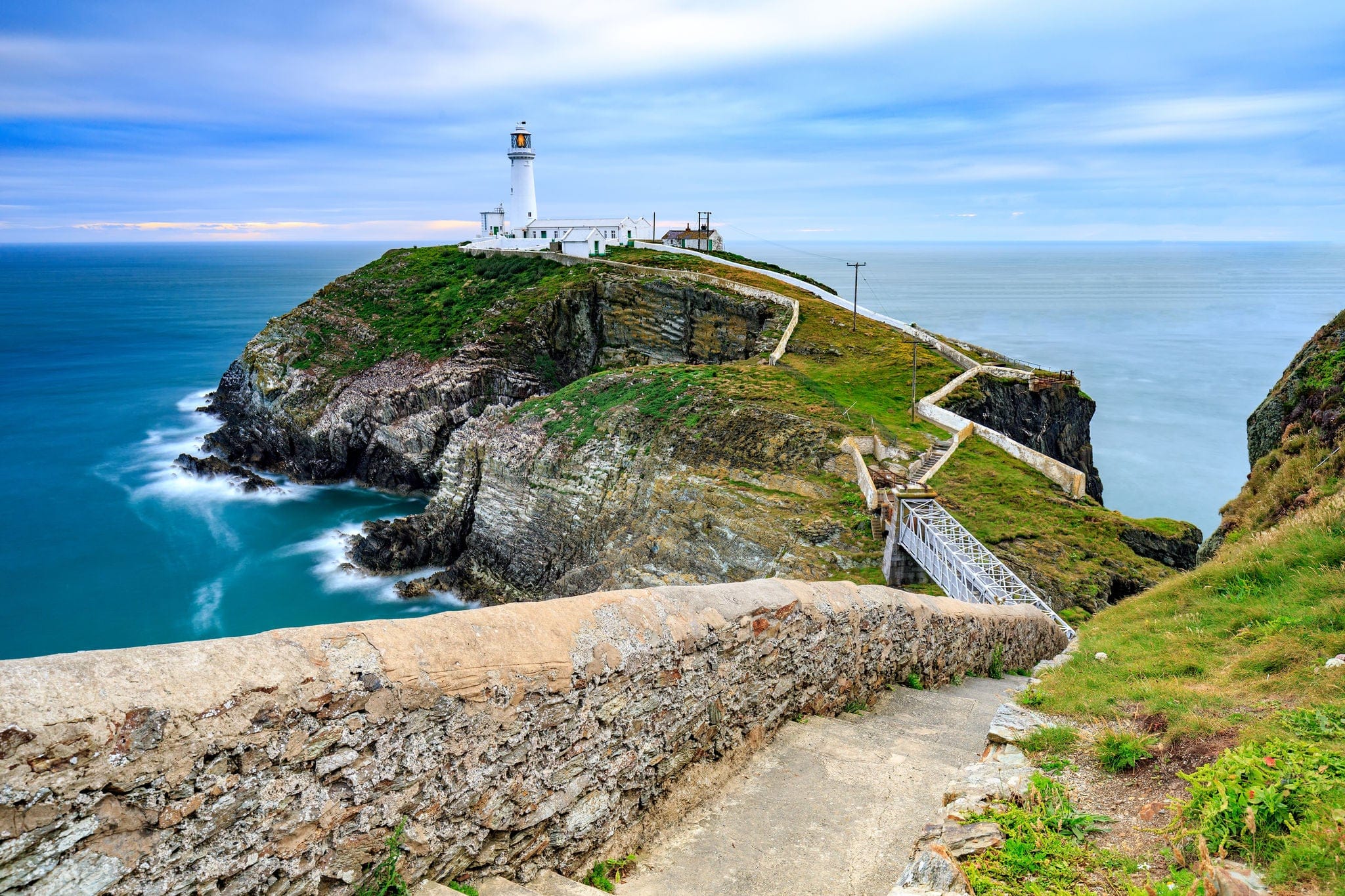 Lighthouse on coastal island with horizon at South Stack in Holyhead, North Wales.
