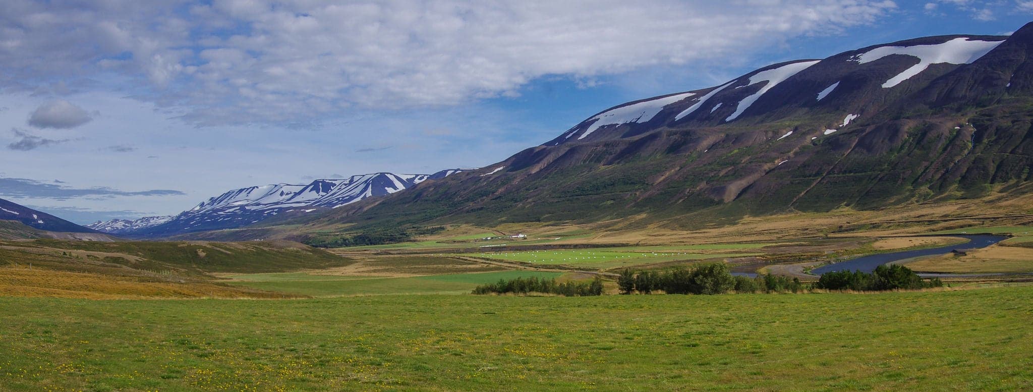 Panorama valley of snow covered mountains. Beautiful summer landscape near ringroad from Akureyri,Iceland.