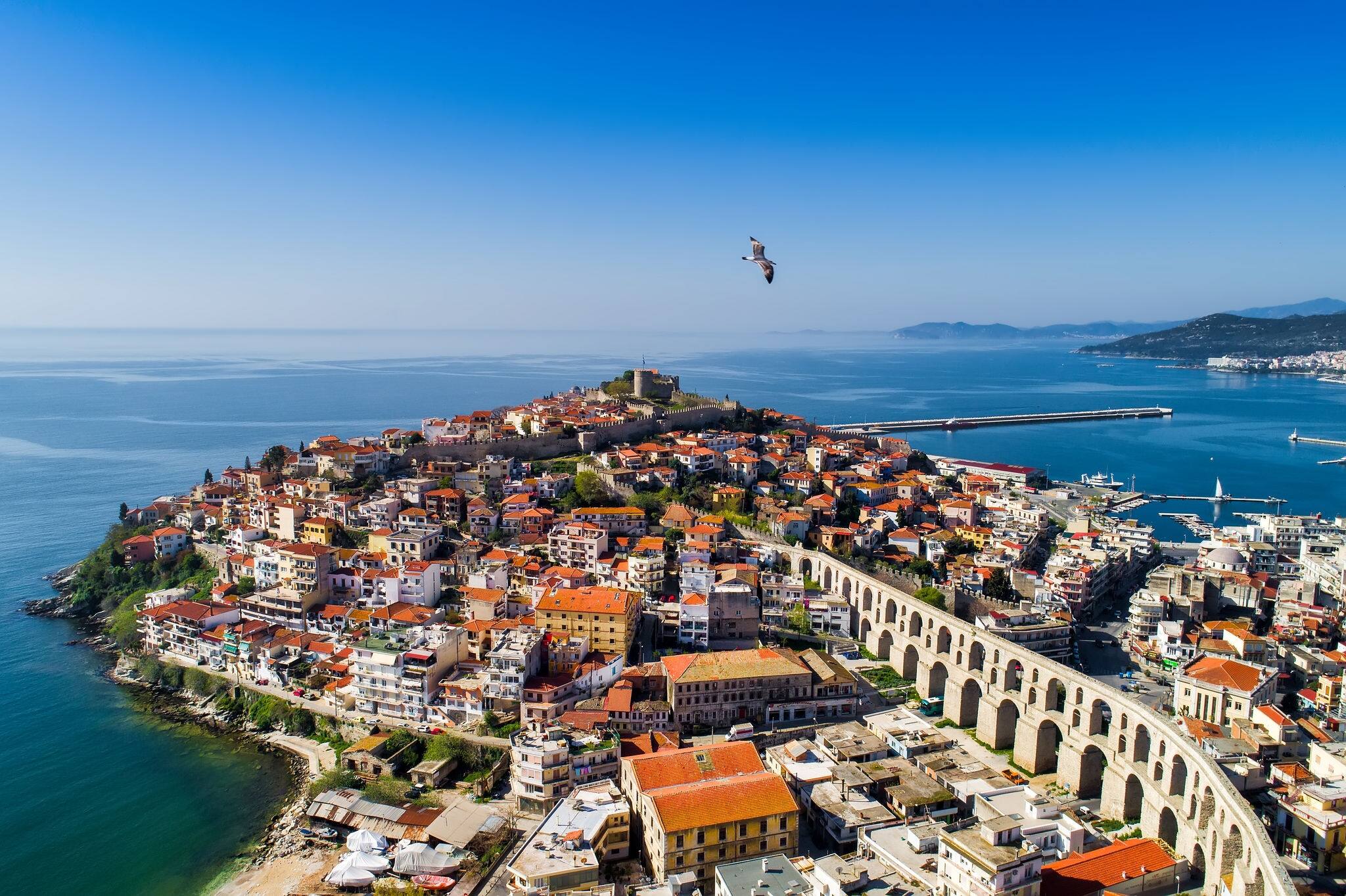 Aerial view the city of Kavala in northern Greek, ancient aqueduct Kamares, homes and medieval city wall 