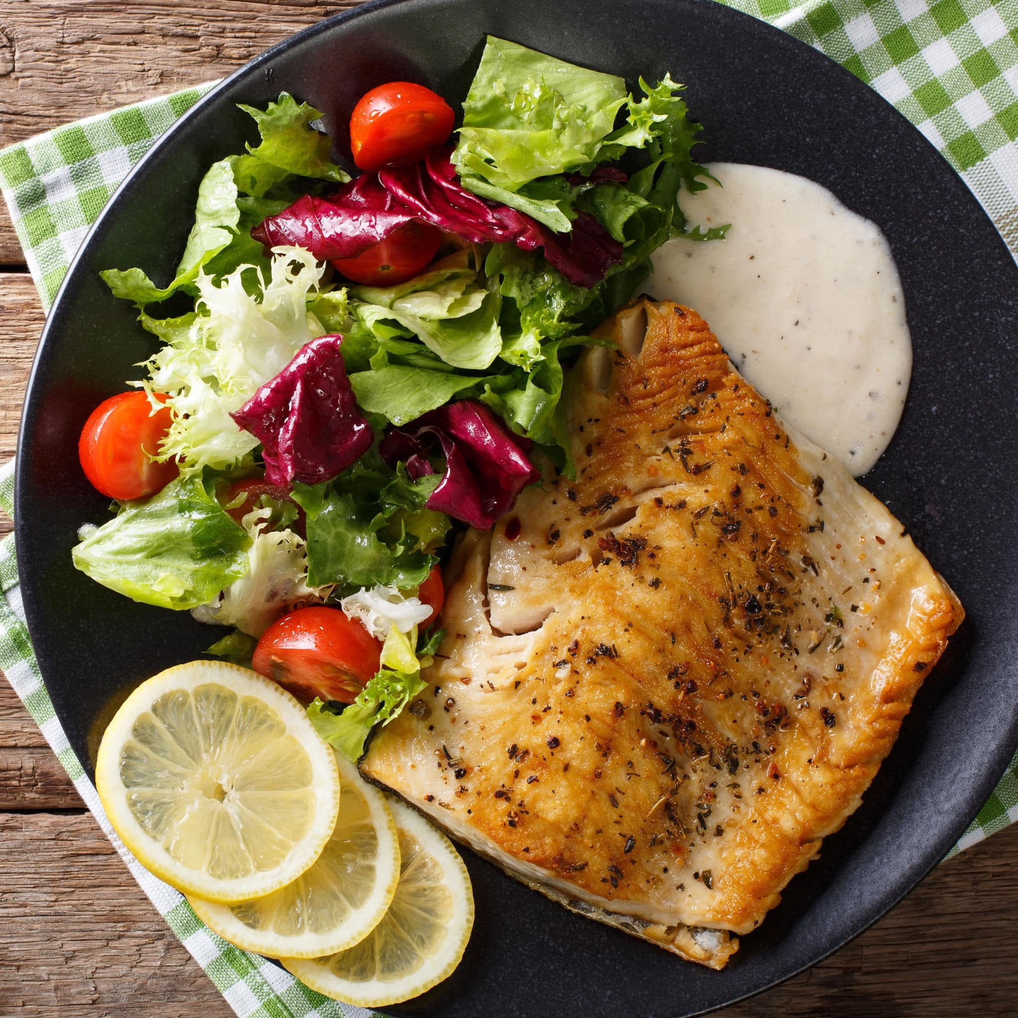 Tasty roasted fish fillet Arctic char and fresh vegetables close-up on a plate. horizontal view from above