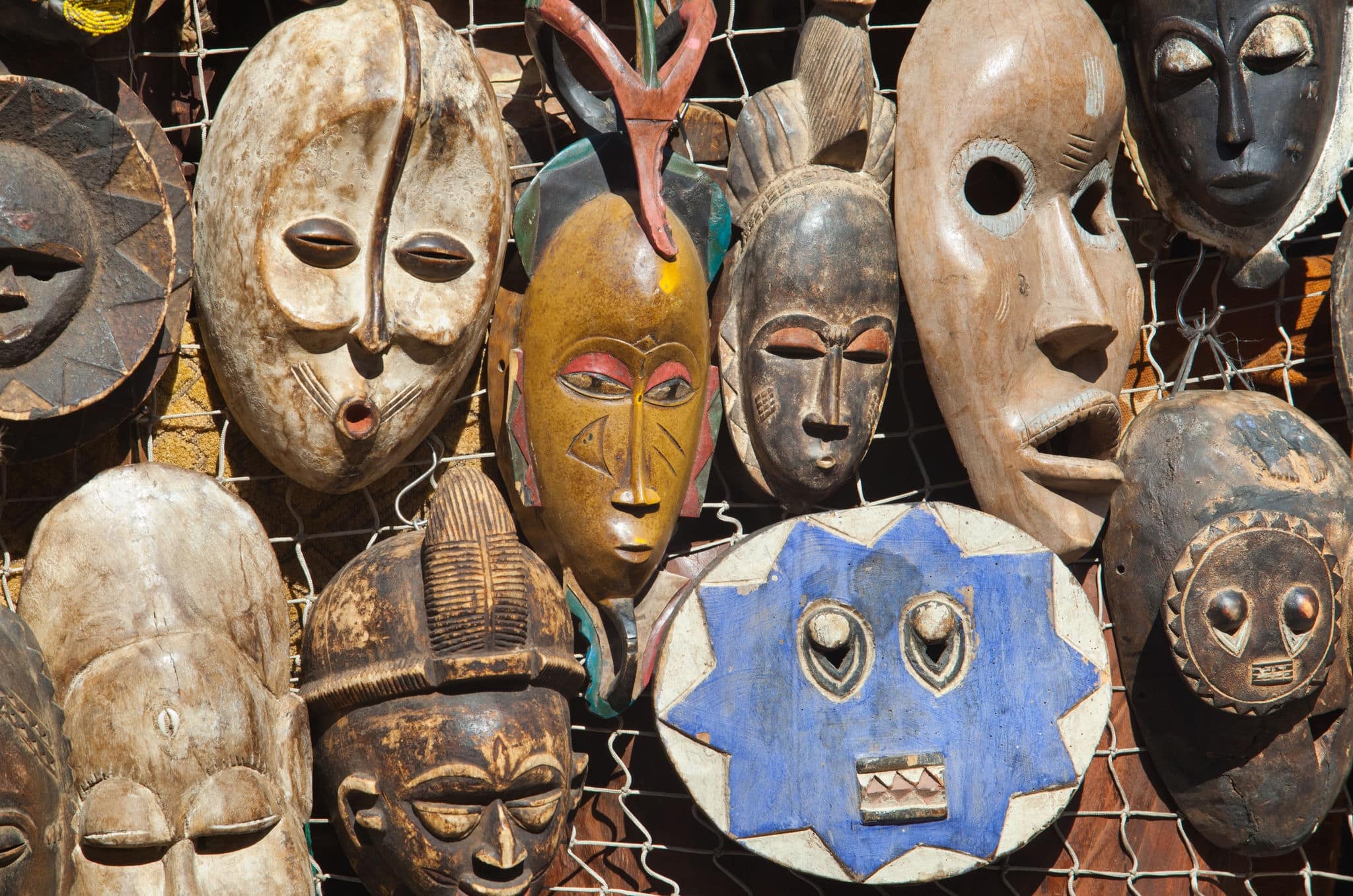 Traditional african masks hanging for sell in a market stall 