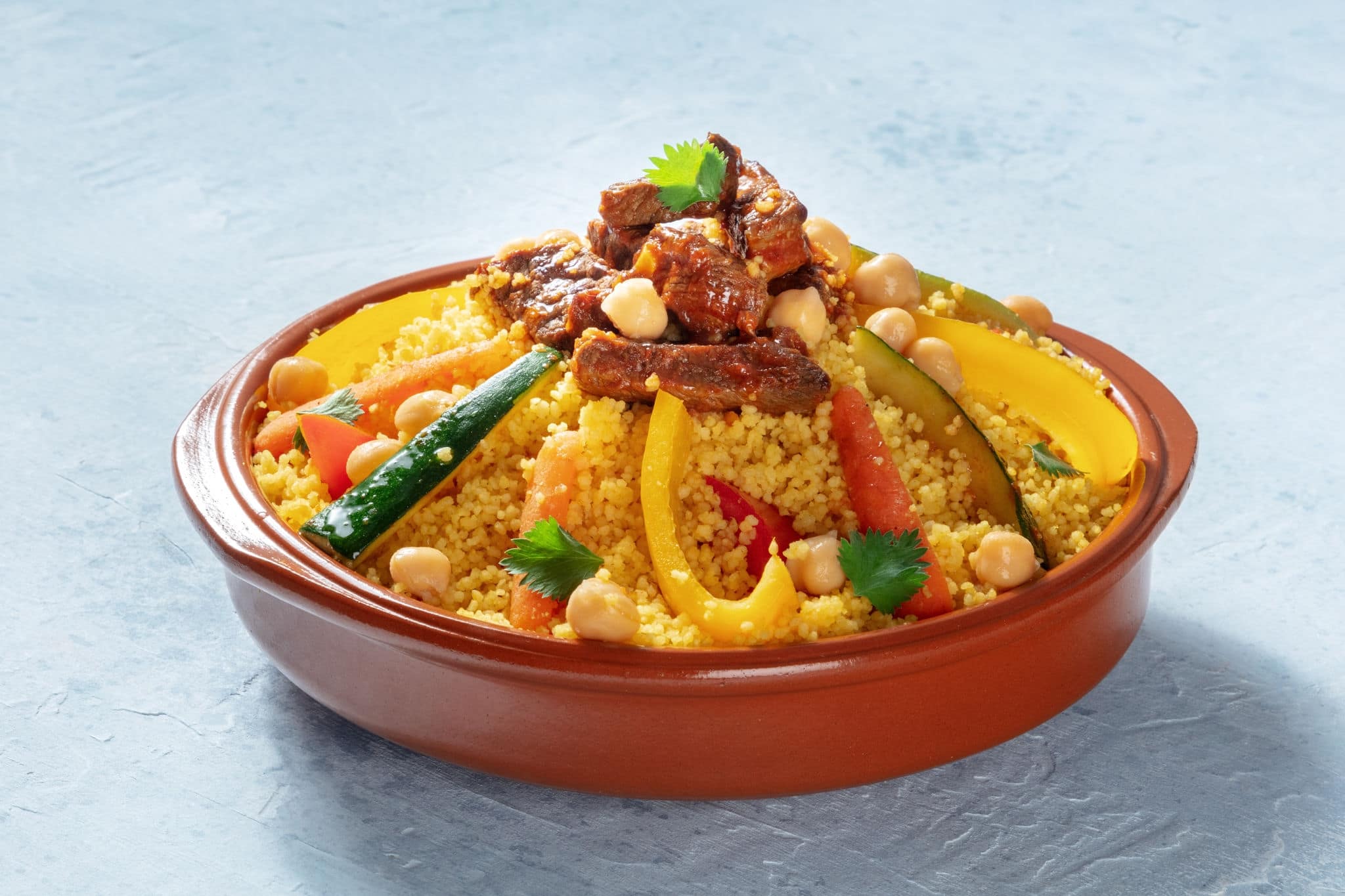 Meat and vegetable couscous in a bowl, typical food from Morocco, a traditional festive Arabic dish with herbs and spices