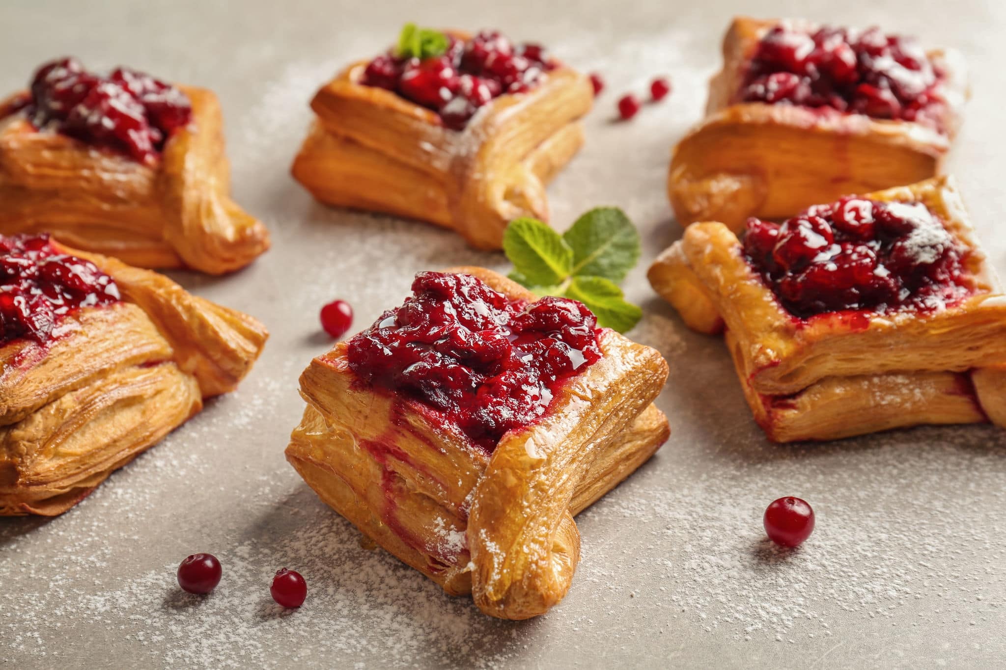 Delicious pastries with cherry jam on light background