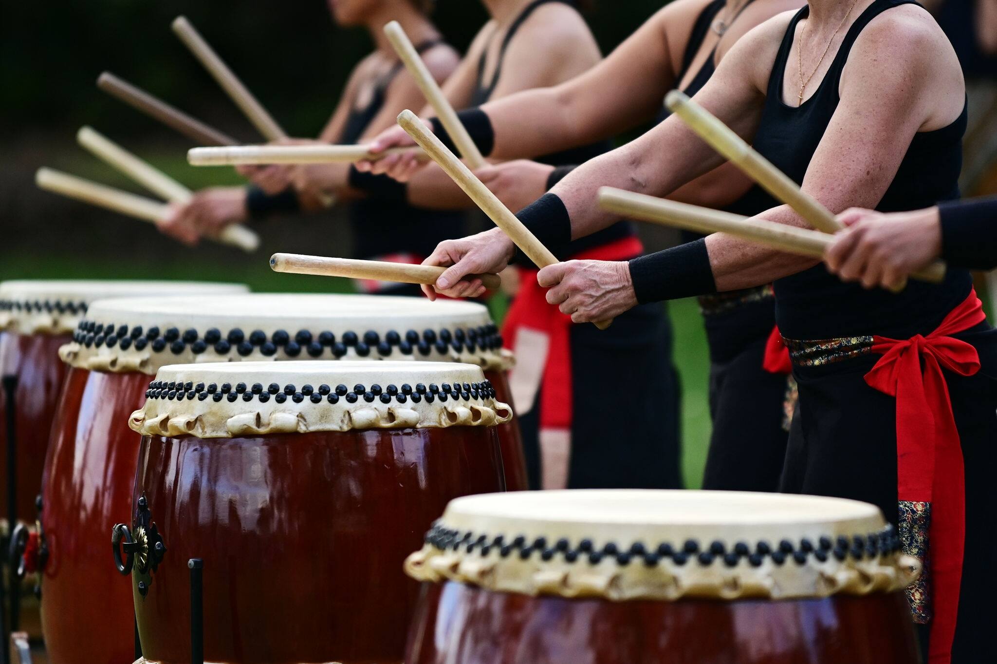 Group of Taiko drummers drumming together on Japanese Drums during a Japanese national holiday in Japan.