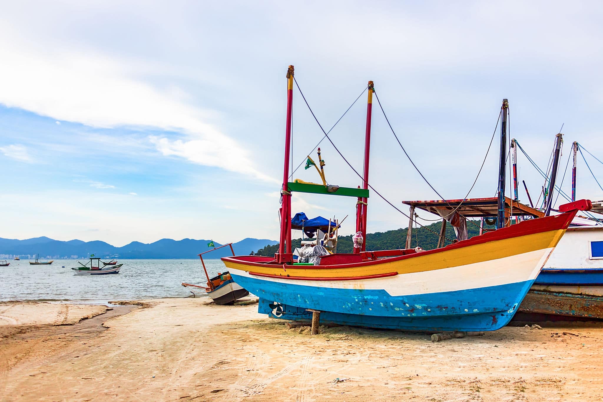 A wooden fishing boat placed in the sand at the costline of Porto Belo, Brazil.