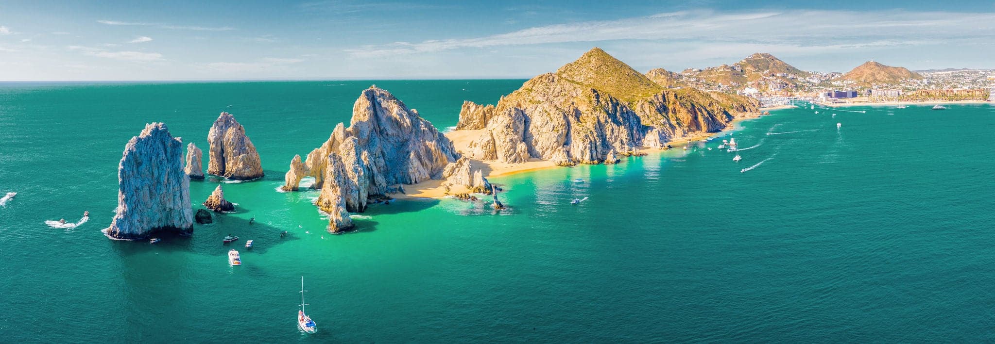 Aerial panoramic view of Lands End and El Arco at the tip of Baja California Sur, with the Cabo San Lucas, Mexico marina in the background