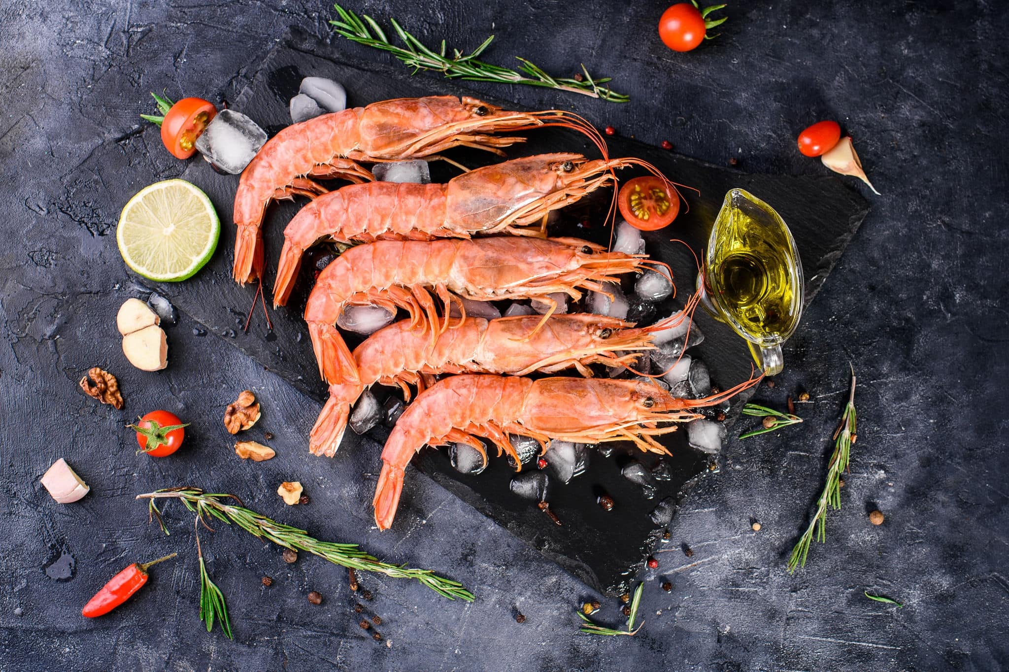 Five large iced langoustines, vegetables, spices, sprigs of defatin, olive oil, lime. Omega, seafood healthy and delicious food