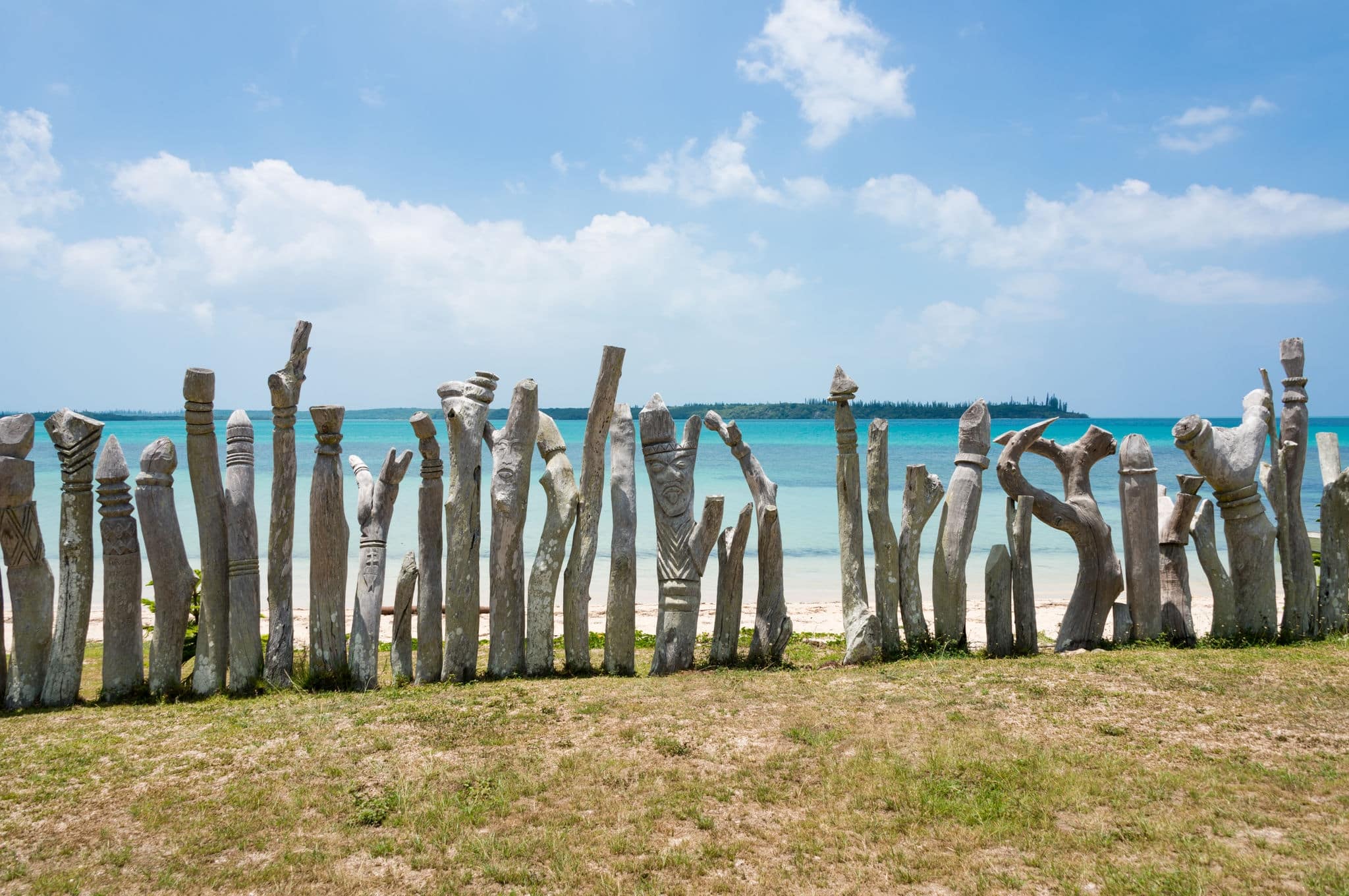 Old wooden geniuses on the beach of the Isle of Pines in New Caledonia