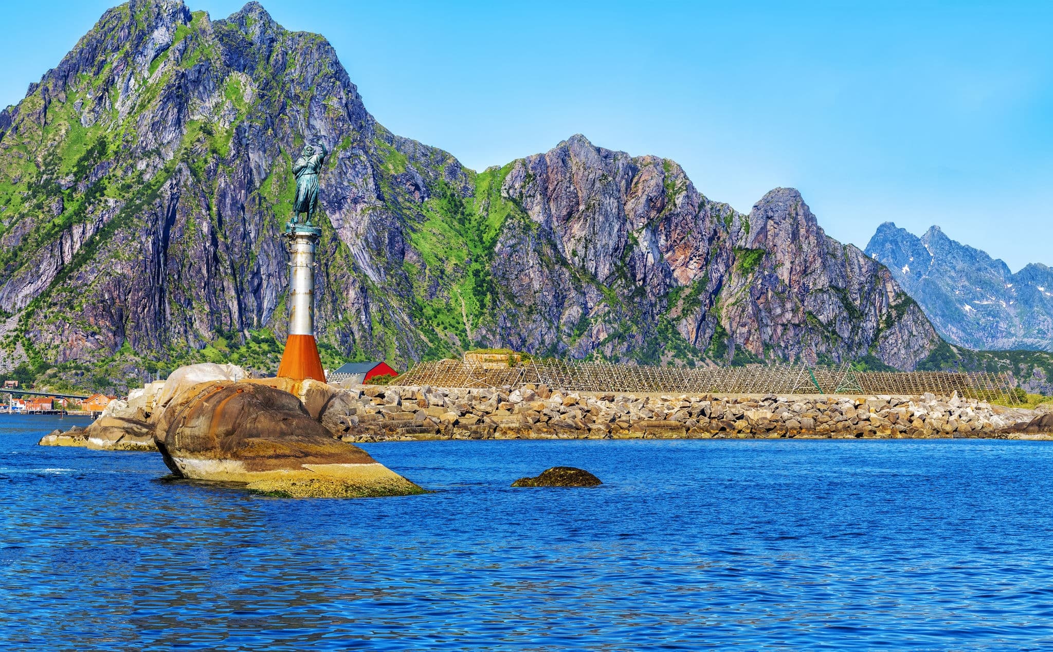 Svolvaer harbour with Statue of the Fisherman's wife and Racks Full Of Dried Codfish in the Lofoten Islands, Norway.