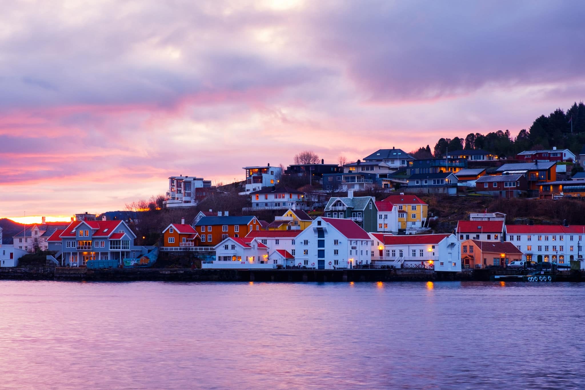 Kristiansund, Norway. View of city center of Kristiansund, Norway during the cloudy morning at sunrise with colorful sky. Port with historical buildings