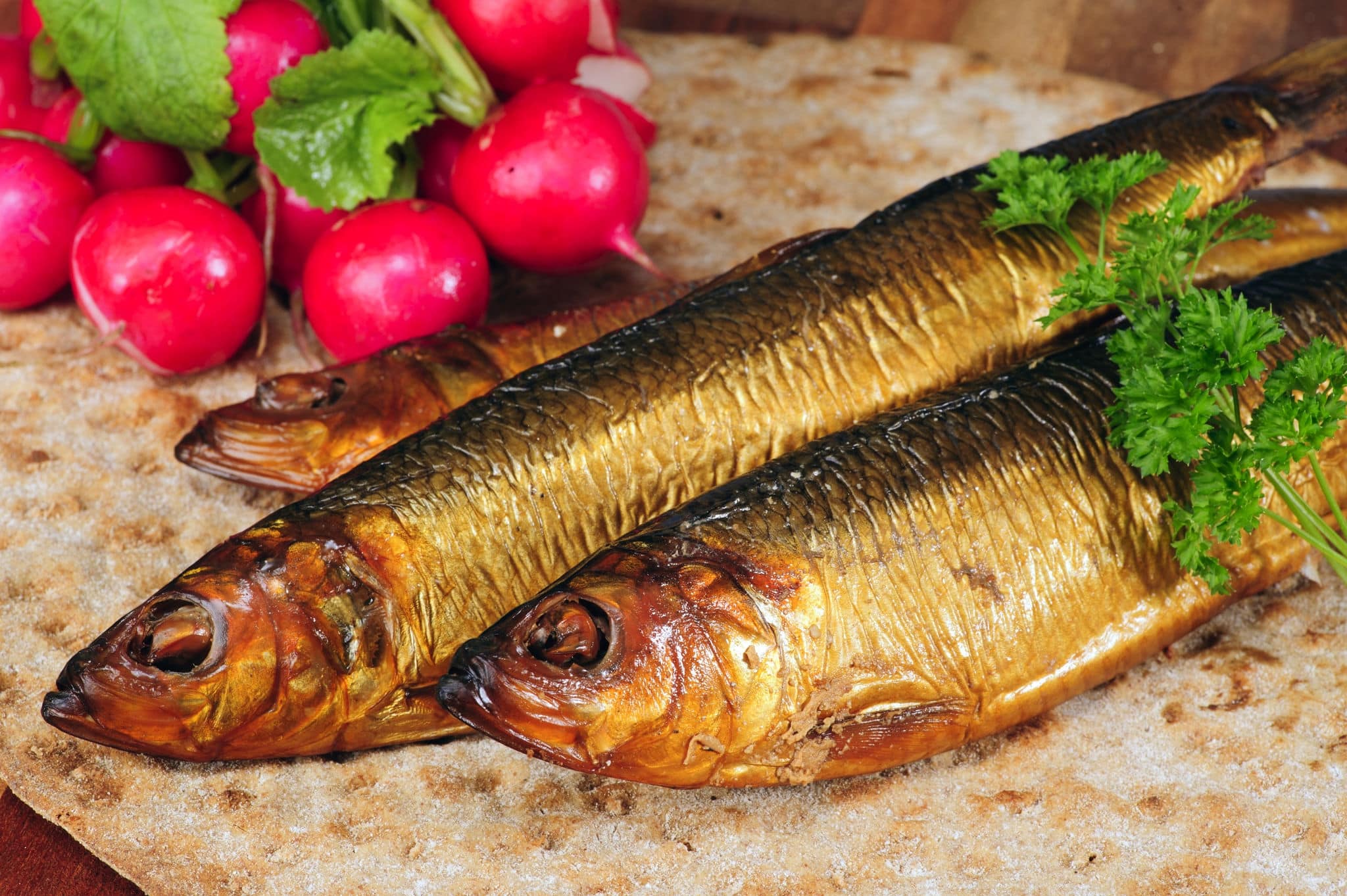Smoked herring on crispbread, decorated with radishes and parsley.