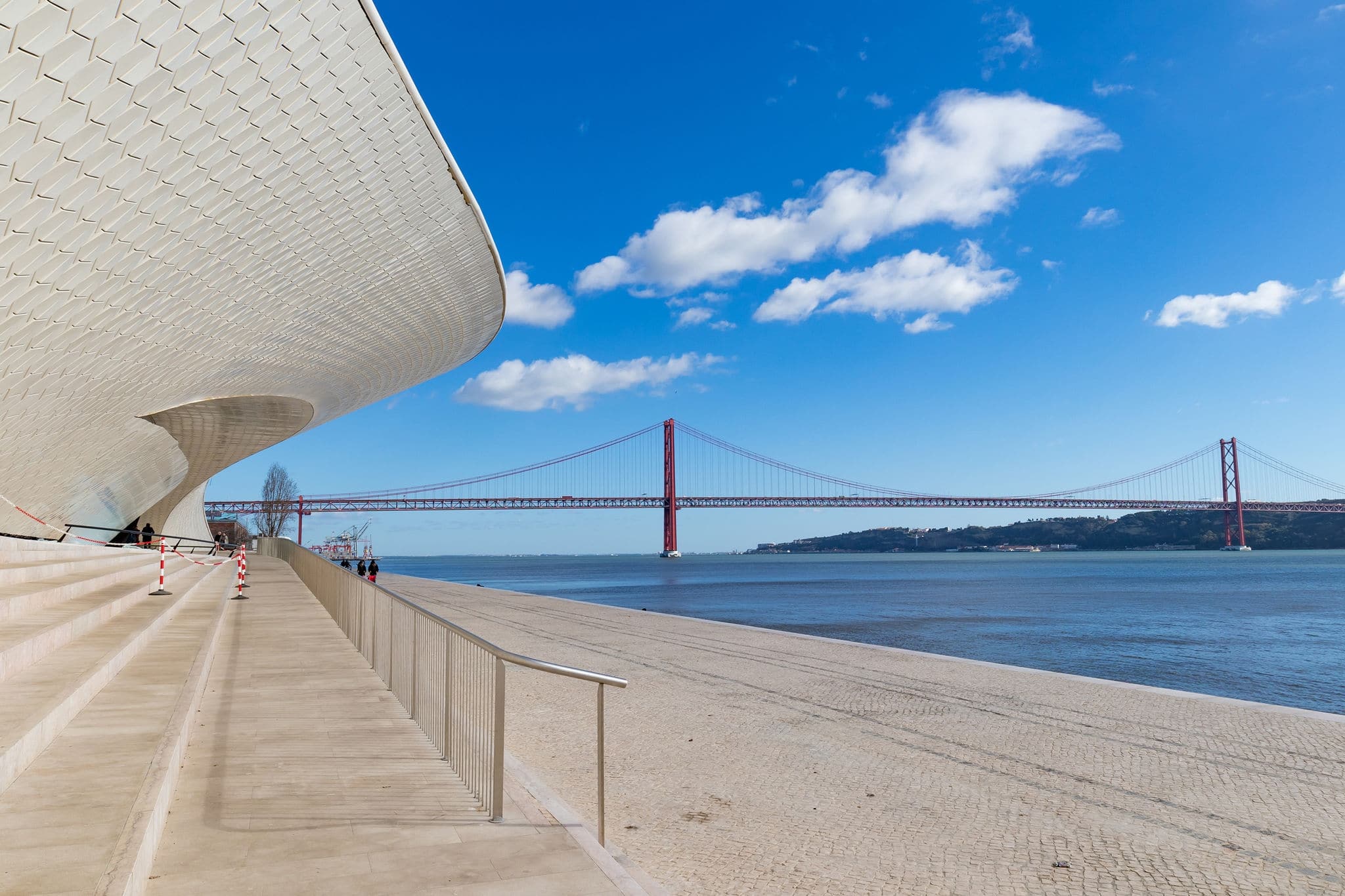 Facade of the new art, technologies and architecture museum in Lisbon. The 25 April bridge over the tagus river