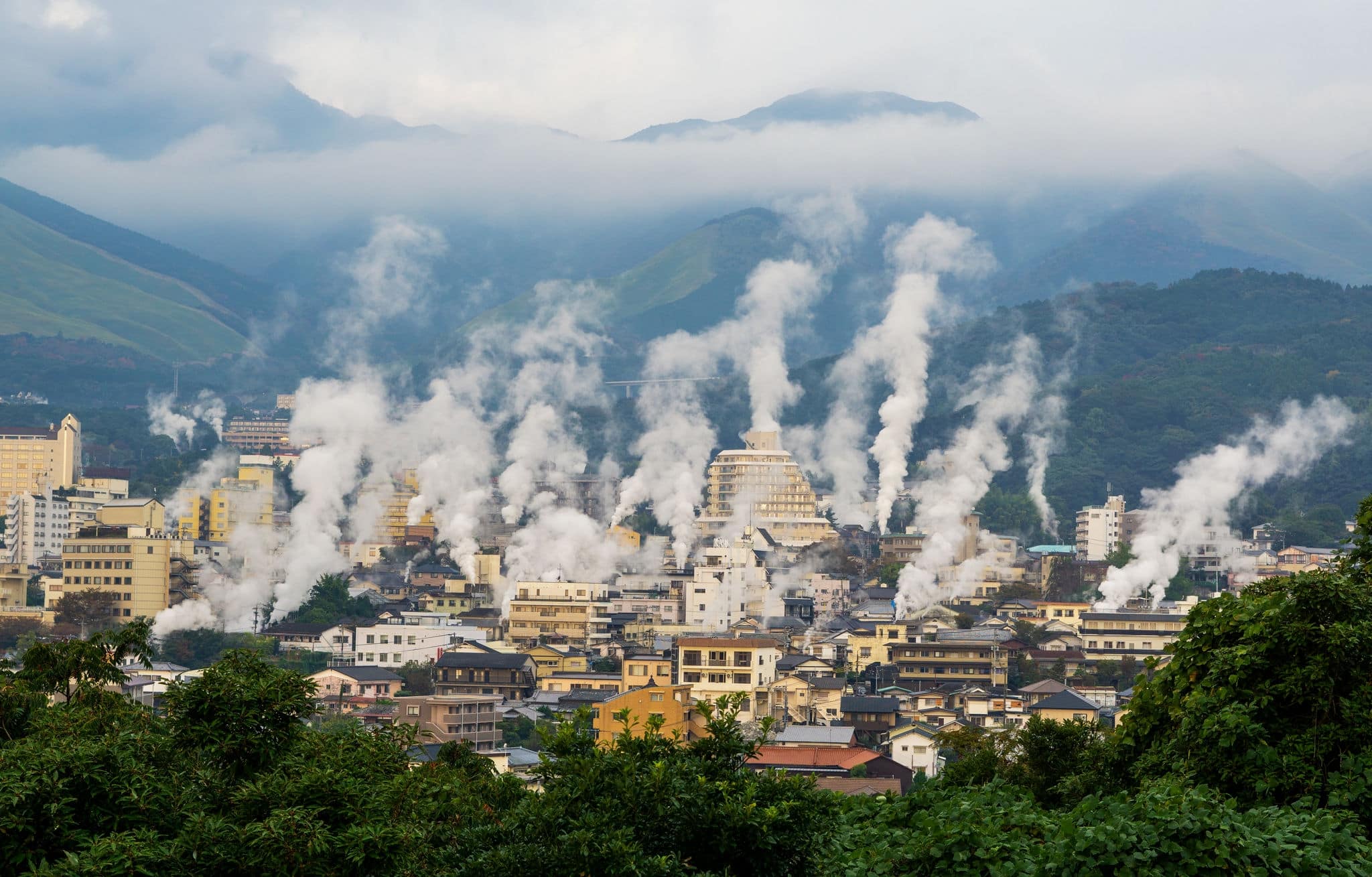 Beautiful scenery of Beppu cityscape with Steam drifted from public baths and ryokan onsen. Beppu is one of the most famous hot spring resorts in Japan, Oita, Kyushu, Japan