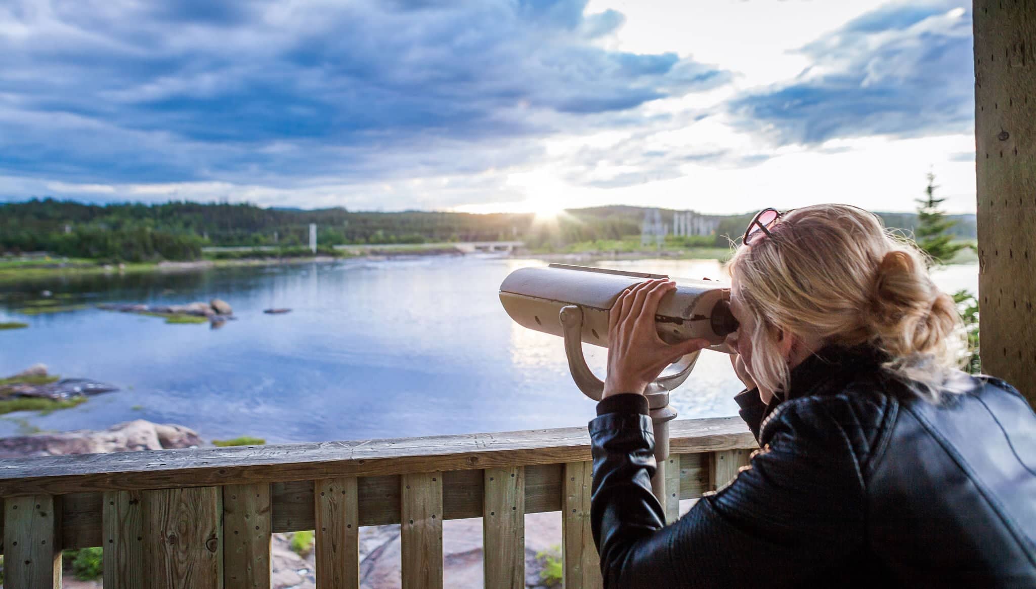 Young Woman Looking at the Amazing Nature Through a Binocular in a Observation Tower in Quebec, Canada.