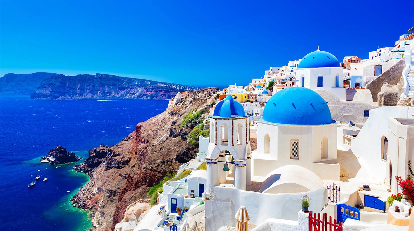 Oia town on Santorini island, Greece. Traditional and famous houses and churches with blue domes over the Caldera, Aegean sea