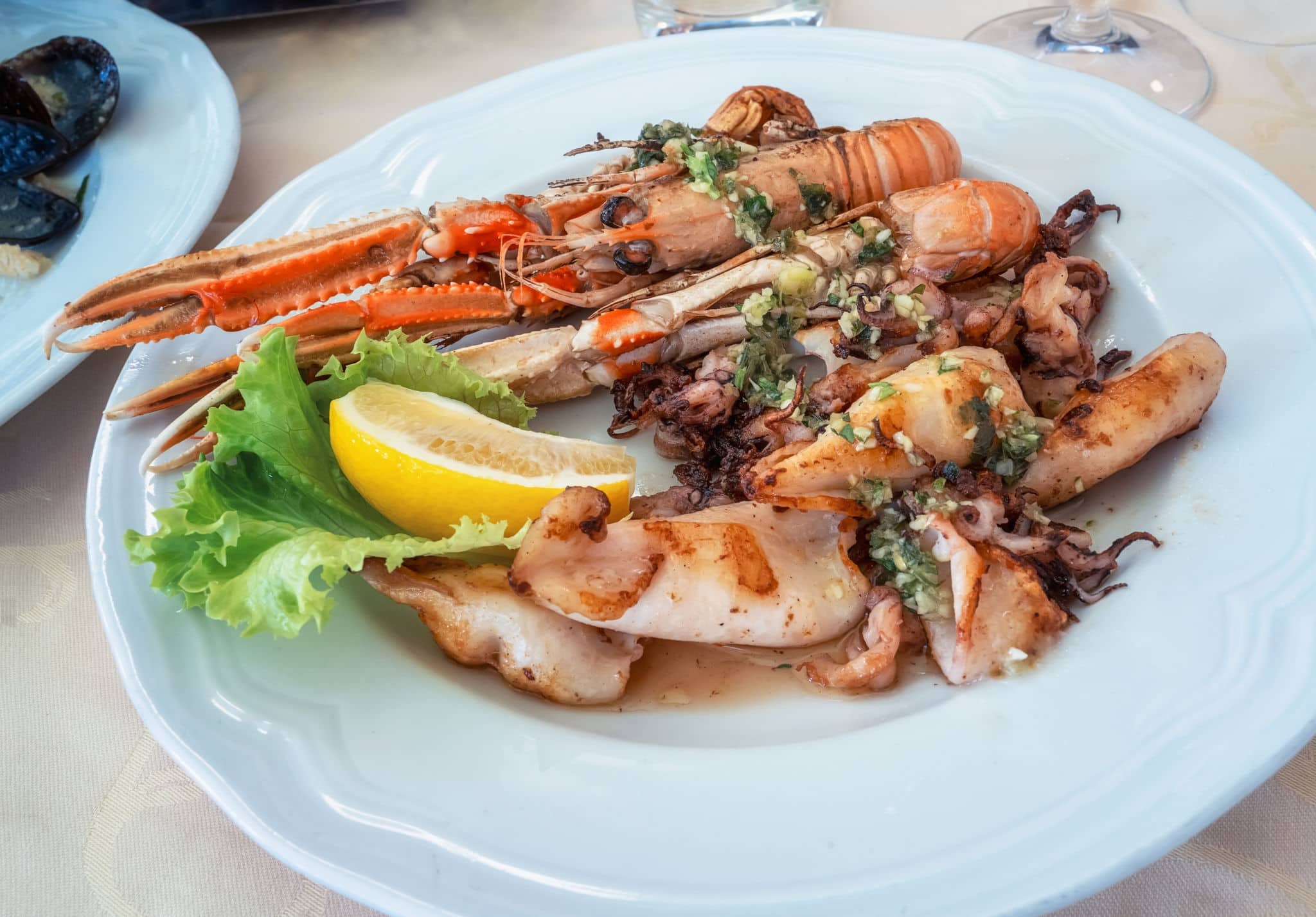A delicious Mediterranean dish of grilled lobster and squids, served on a platter in a small restaurant on the main promenade of Piran, Slovenia