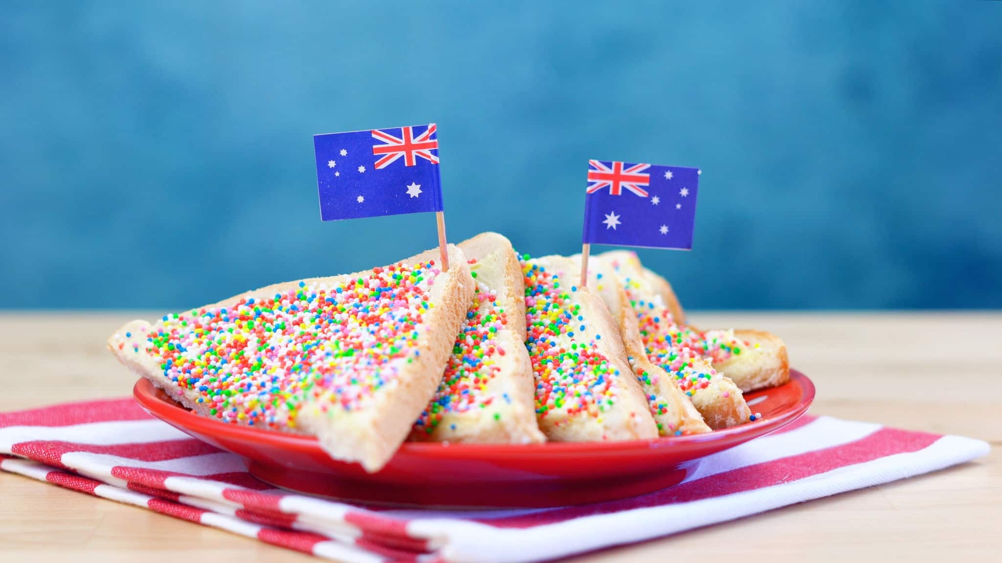Iconic traditional Australian party food, Fairy Bread, on a red, white and blue background.