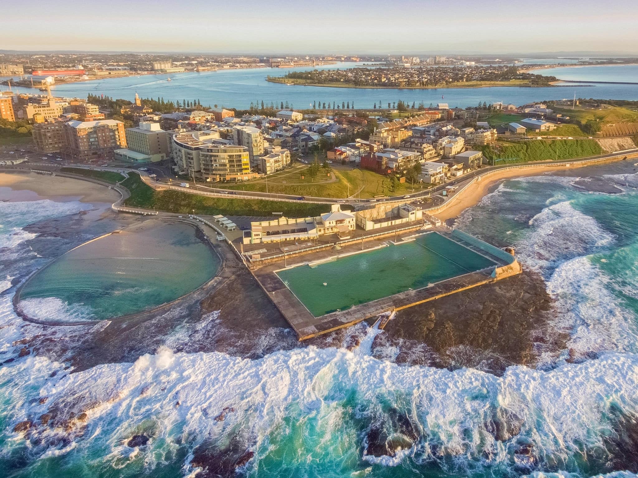 Aerial shot of sun rising over the Newcastle Ocean Baths, NSW, Australia