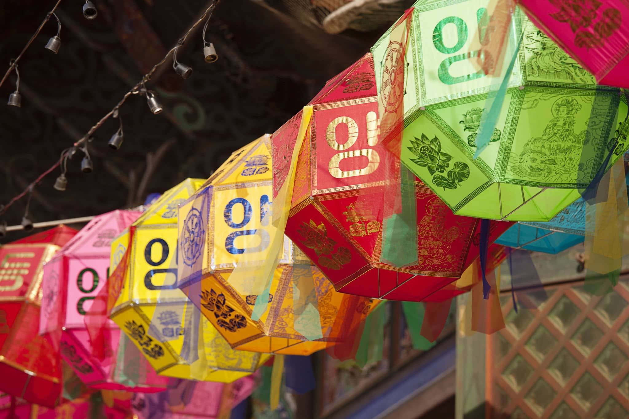 A string of colored paper lanterns hang over the outside entrance to the Buddhist temple of Bongeunsa in Seoul, South Korea.