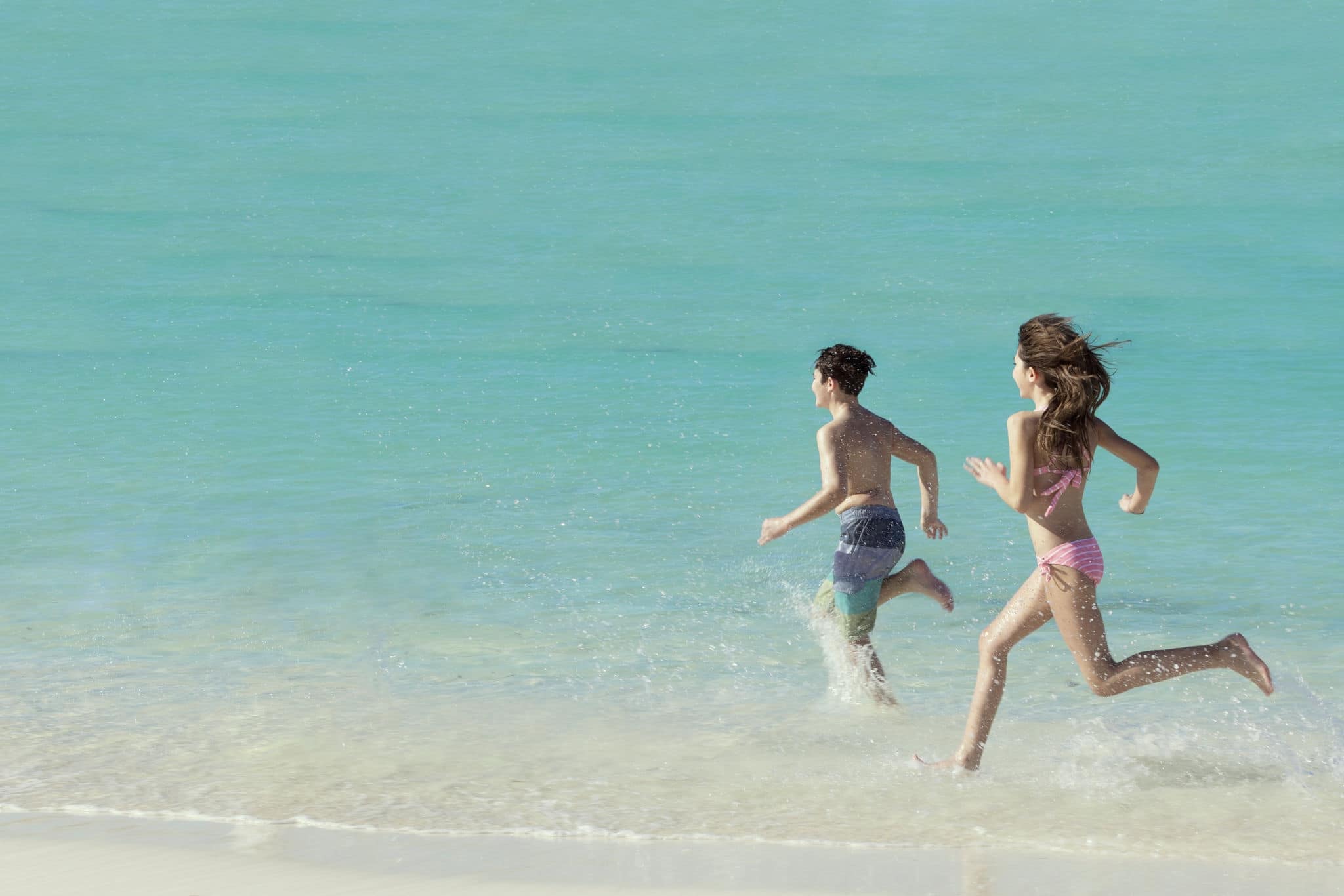Kids running on the beach. 