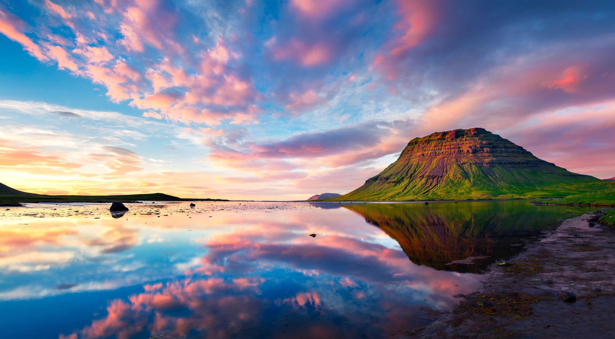 Colorful summer sunset with Kirkjufell Mountain in Grundarfjordur town. Evening scene on the Snaefellsnes peninsula, Iceland, Europe. Artistic style post processed photo.