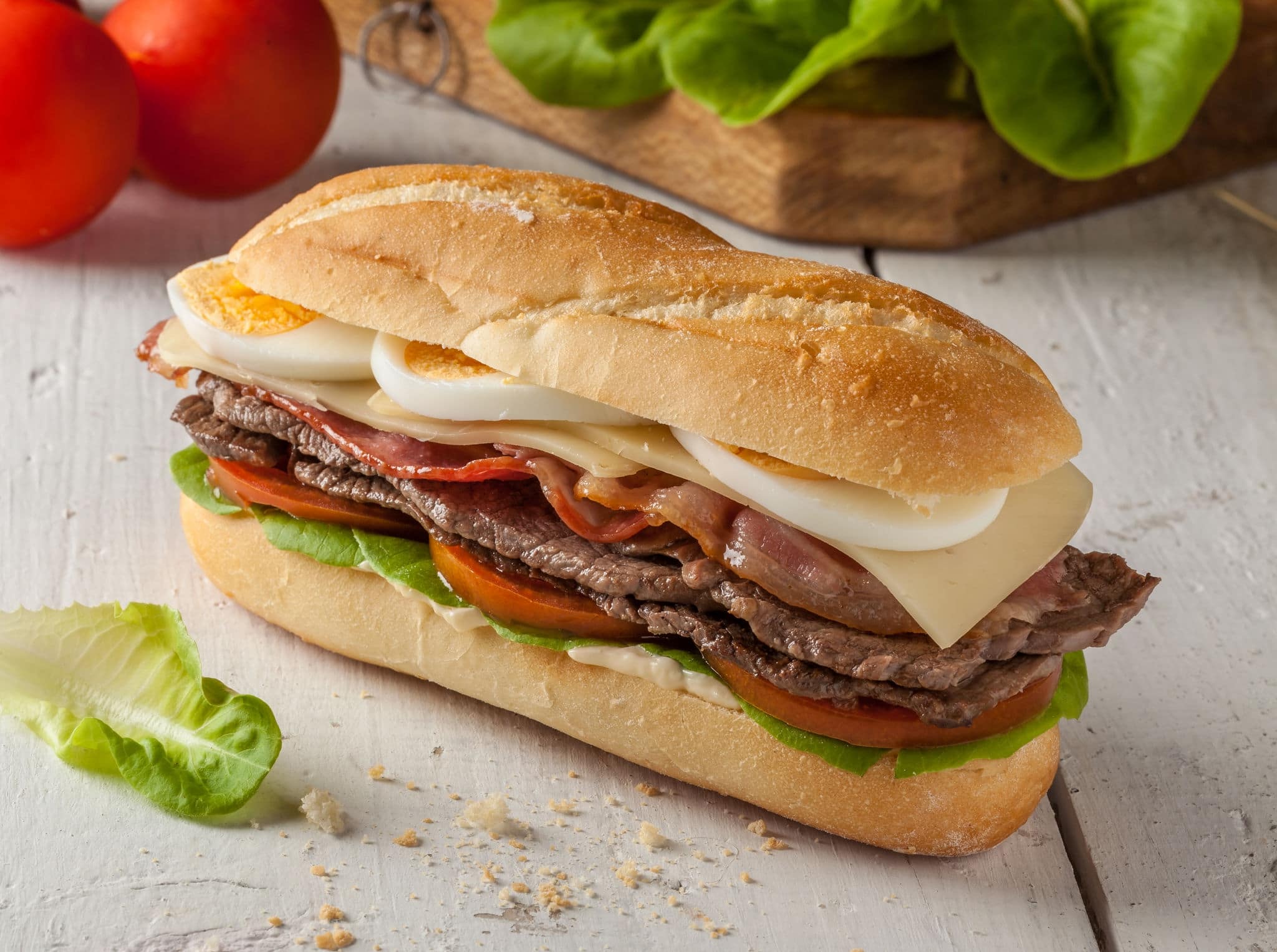Chivito is a typical sandwich from Uruguay, with lettuce, tomato, bacon, beef, fried or boiled eggs and cheese.