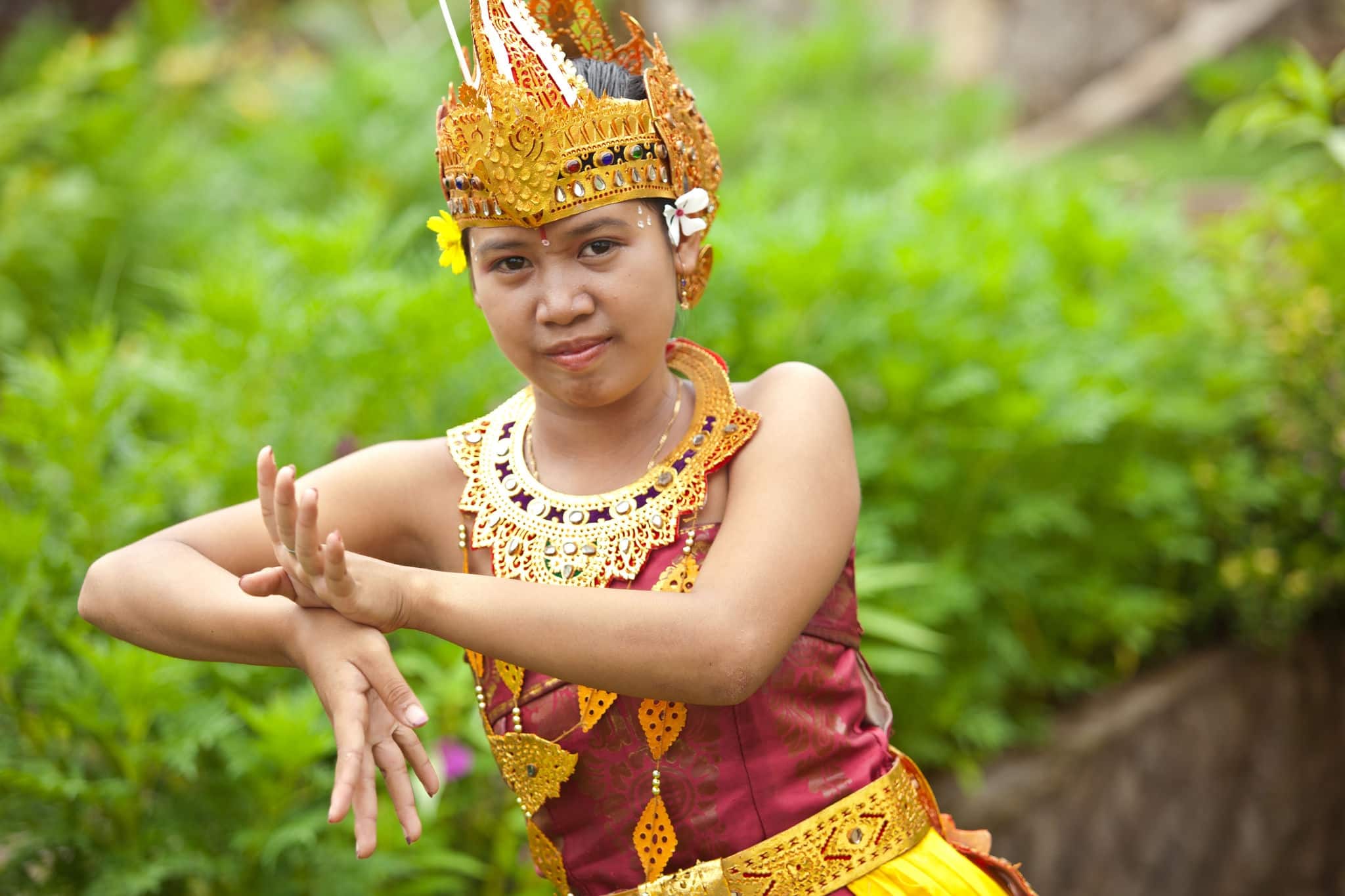 Young Balinese female dancer performing traditional Legong dance