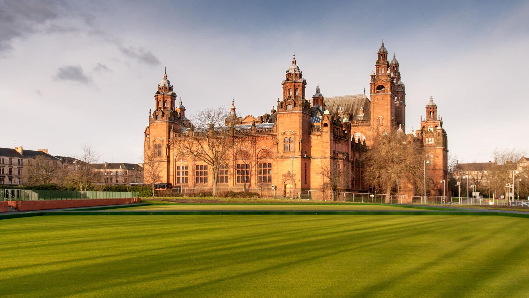 Glasgow, Scotland, UK - January 19, 2012: The grand Victorian Kelvingrove Museum and Art Gallery stands illuminated by evening sun amongst lawns in Glasgow's West End.