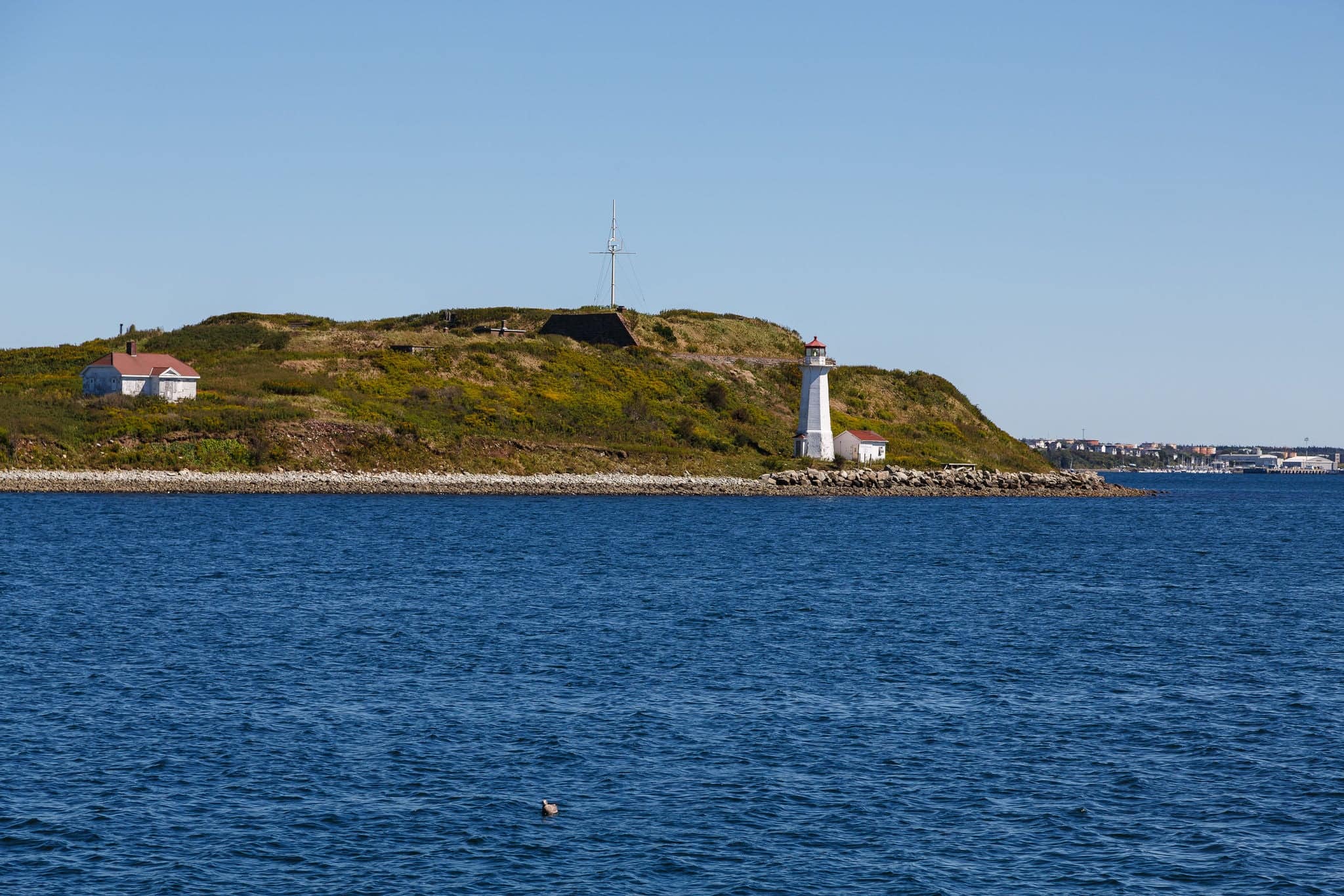 White Lighthouse on shore of green island near Halifax, Nova Scotia