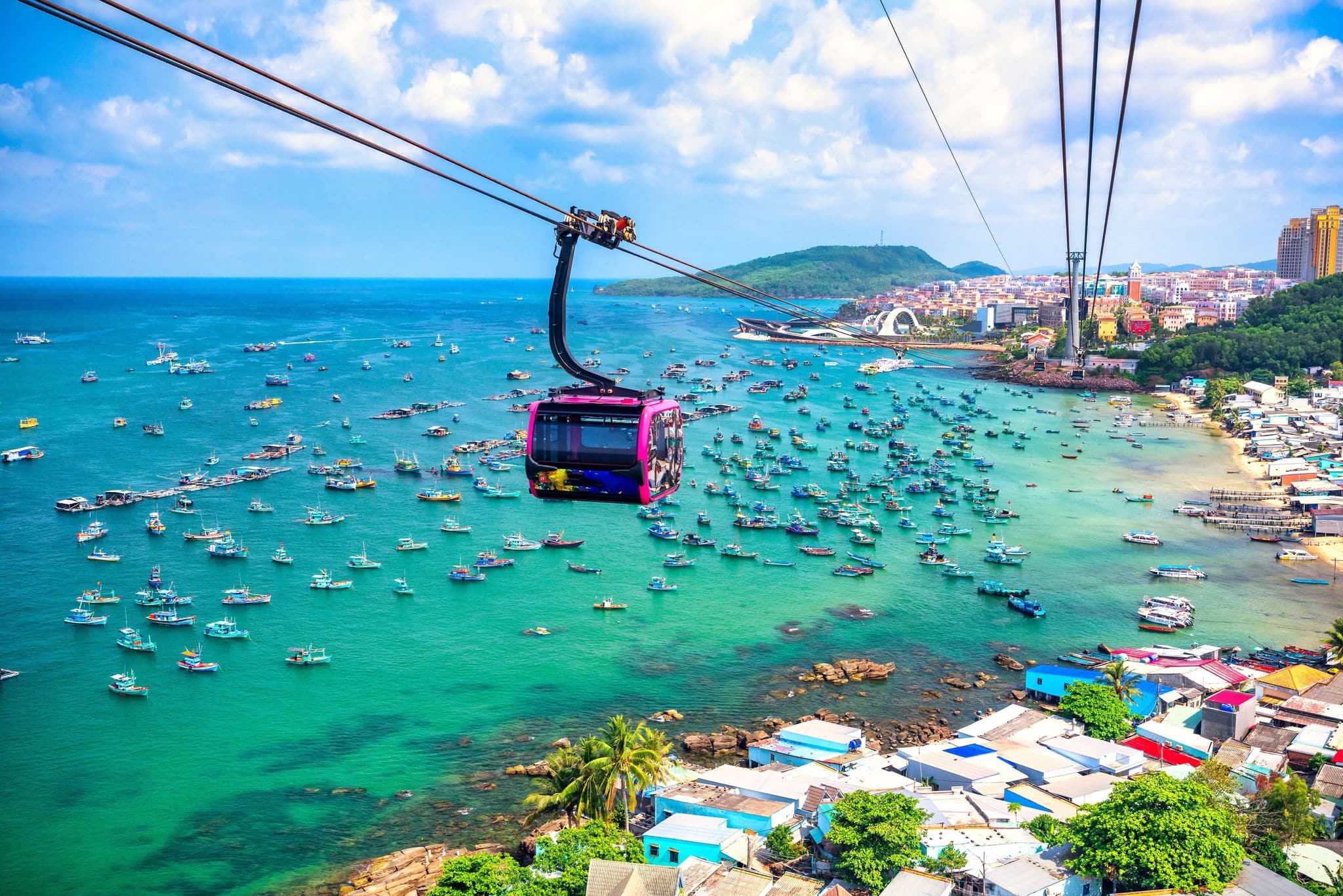 Aerial view of a cable car over a tropical beach