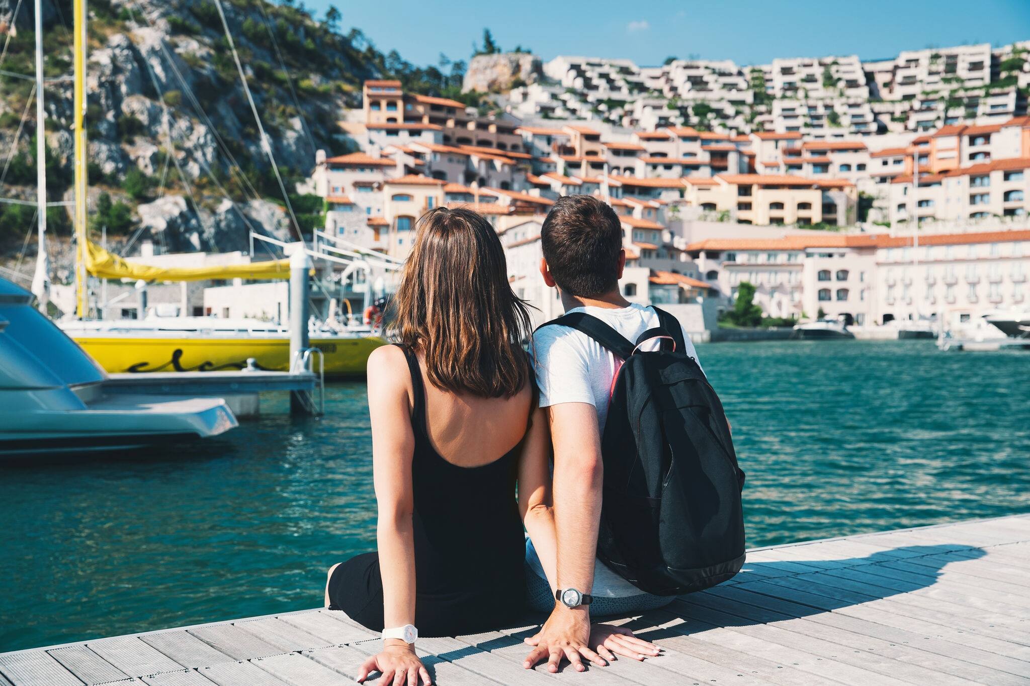 Young couple in love walking in Portopiccolo Sistiana, Italy, Europe. Lifestyle, Holidays and Travel Concept.