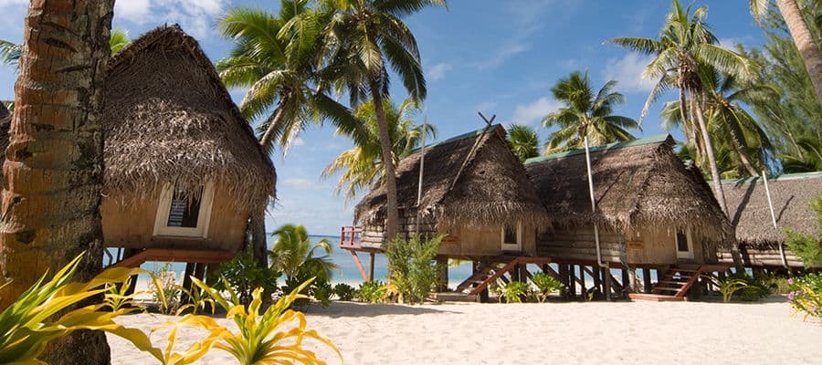 Beachfront view of bungalows along Aitutaki beach shore.
