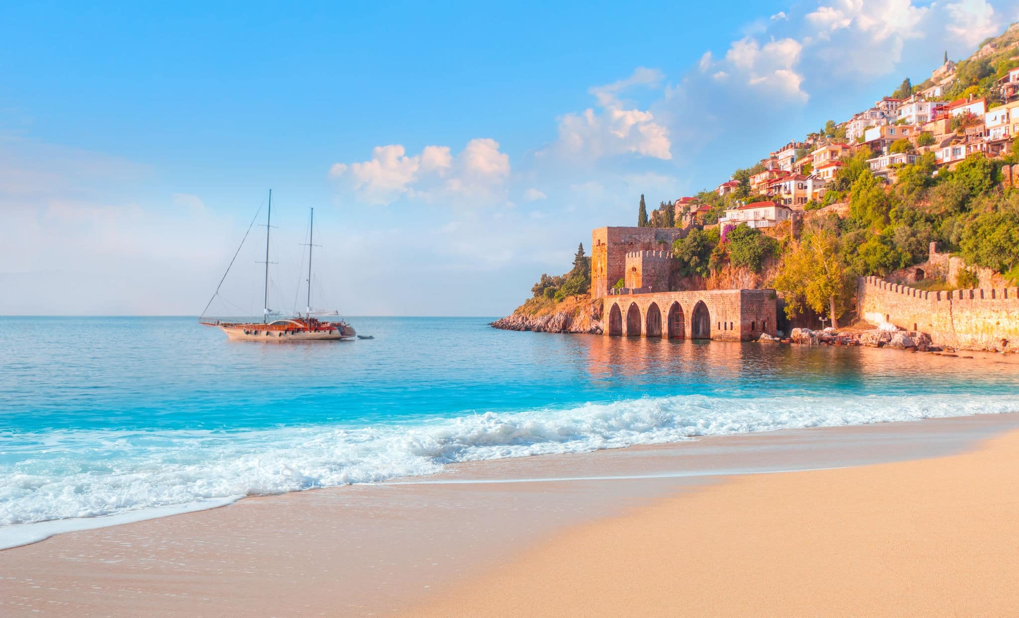 Beautiful sandy beach and soft turqoise Mediterranean sea wave - Landscape of ancient shipyard near of Kizil Kule tower - Alanya peninsula, Turkey
