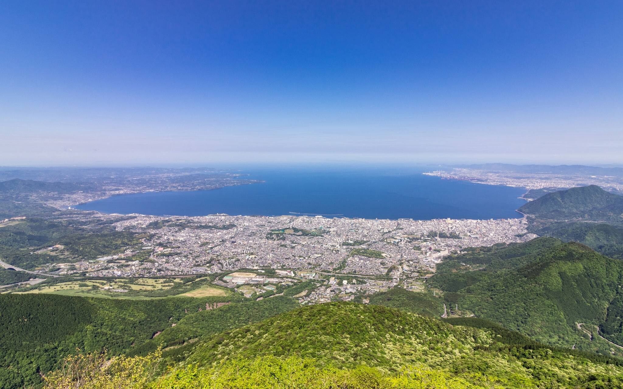 Panorama of Beppu City and Bay between Mountains of Kyushu and green Landscape in the foreground from Mount Tsurumi. Beppu, Oita Prefecture, Japan, Asia.