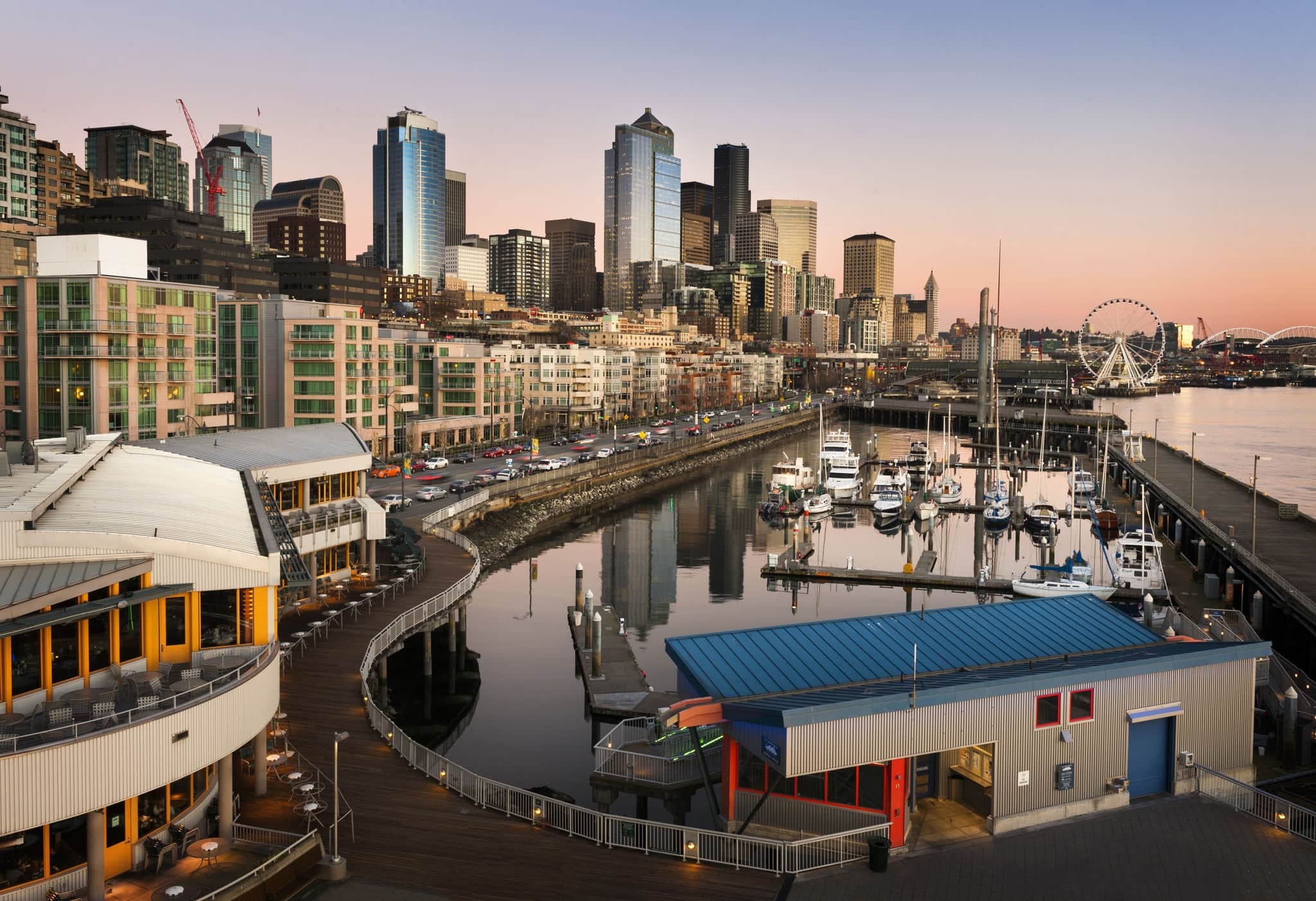 Seattle Waterfront at Sunset. The Seattle, Washington waterfront and skyline at sunset with a marina and ferris wheel. The Port of Seattle can be seen in the background.