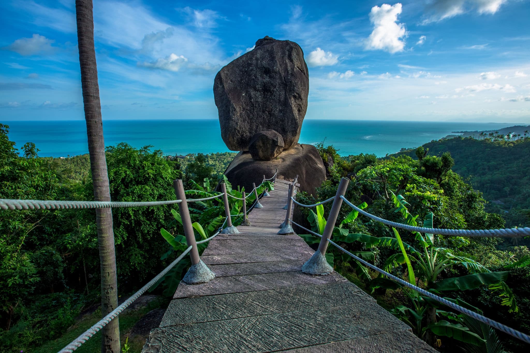 Background of evening natural light on high mountains overlooking the sea, coconut palms, hillside villas and large rocks on Koh Samui