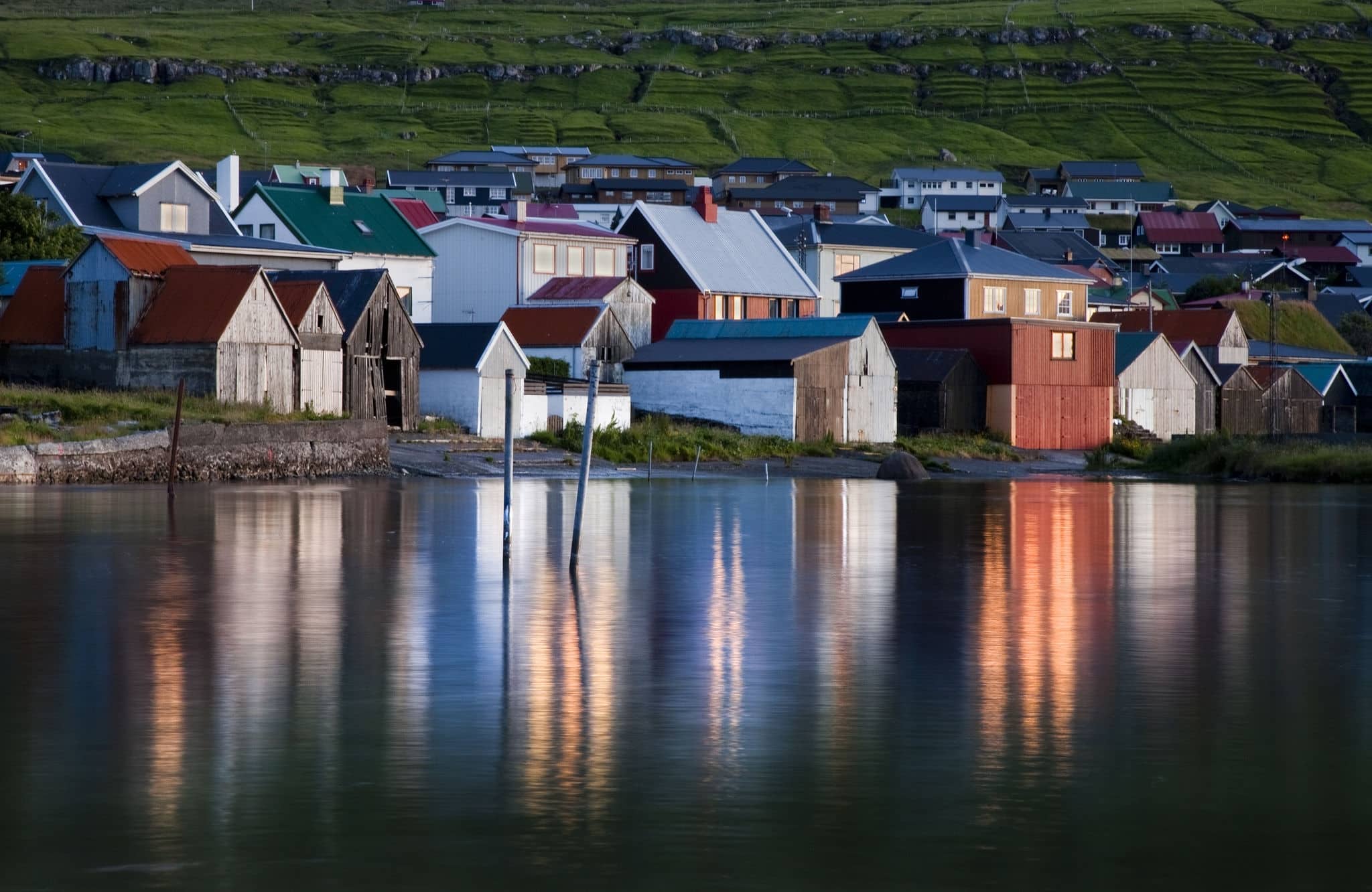 Reflexion of houses in the sea in harbor village Leirvik.