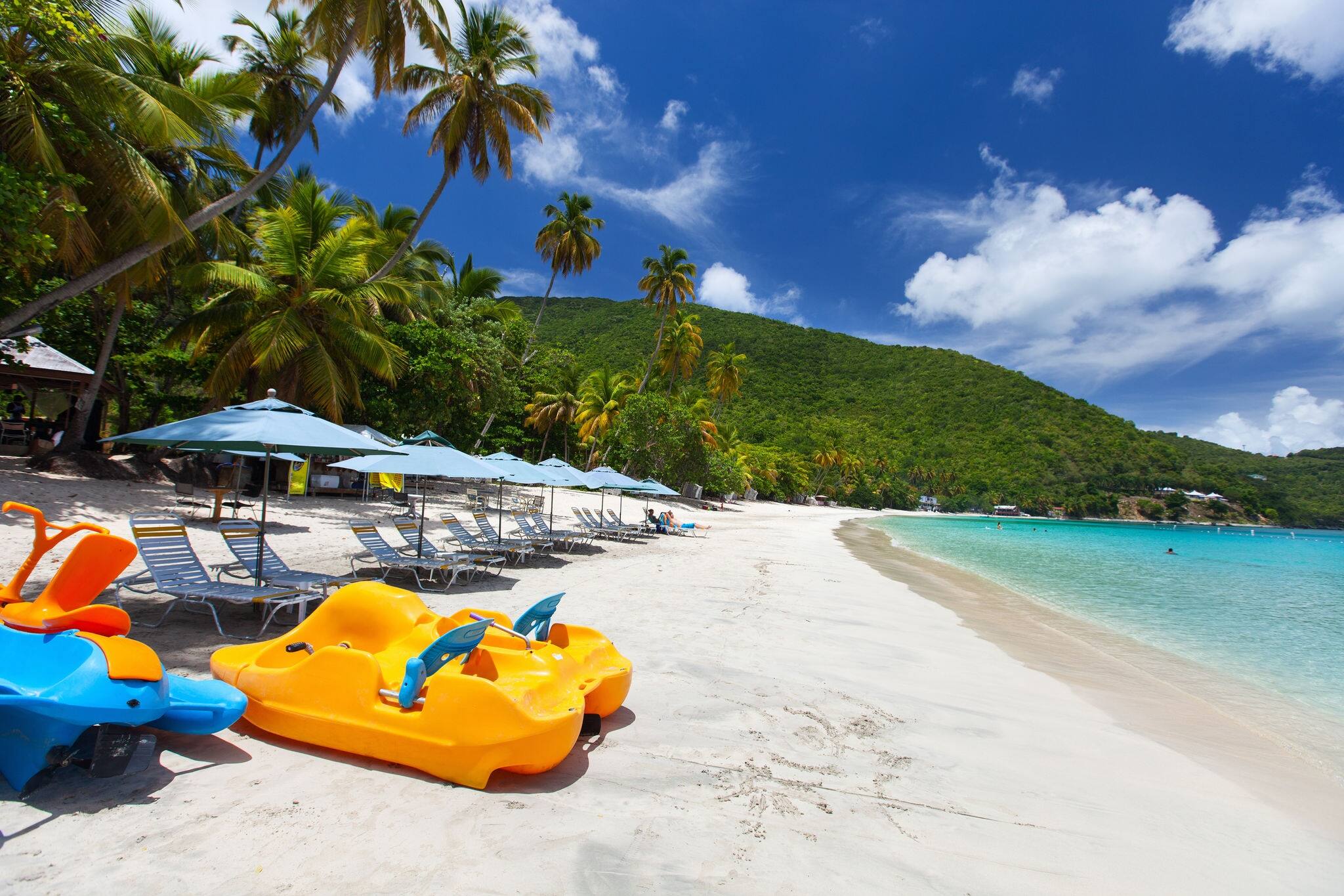 Beautiful tropical beach with palm trees, white sand, turquoise ocean water and blue sky at Tortola, British Virgin Islands in Caribbean