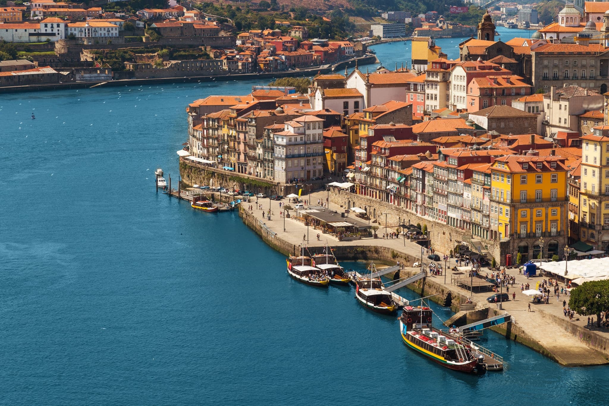 View on the old town and historic centre of Porto, Portugal. Red roofs, river and boats on a sunny day. Unesco heritage. View from the Louis Pont Bridge.