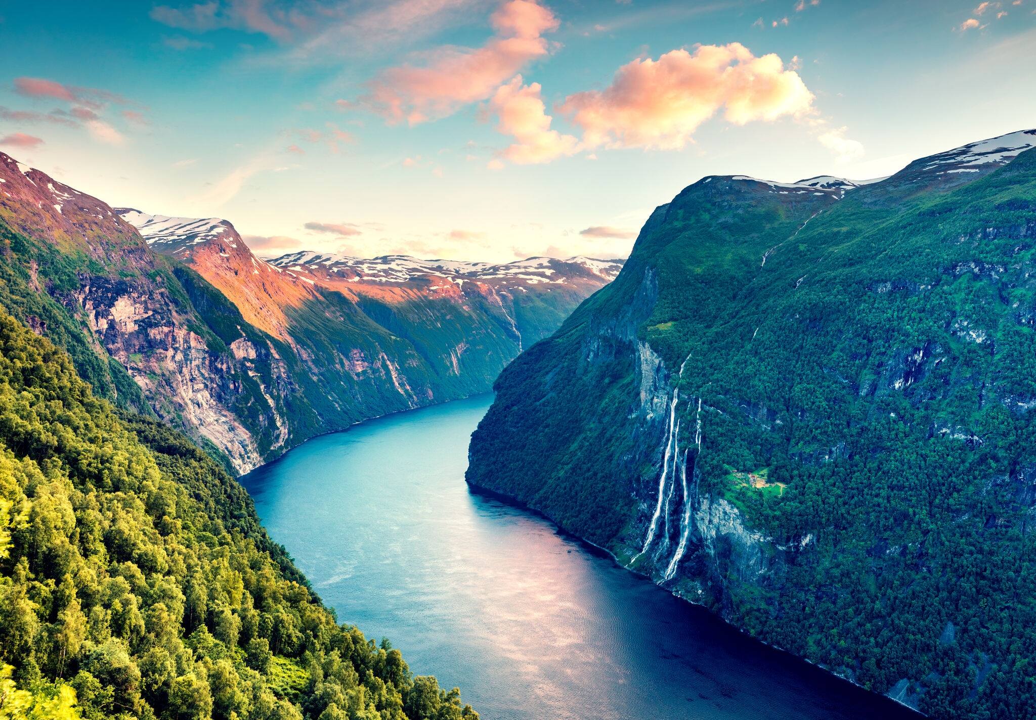 Splendid summer sunset of Sunnylvsfjorden fjord canyon, Geiranger village location, western Norway. Aerial evening view of famous Seven Sisters waterfalls. Beauty of nature concept background.