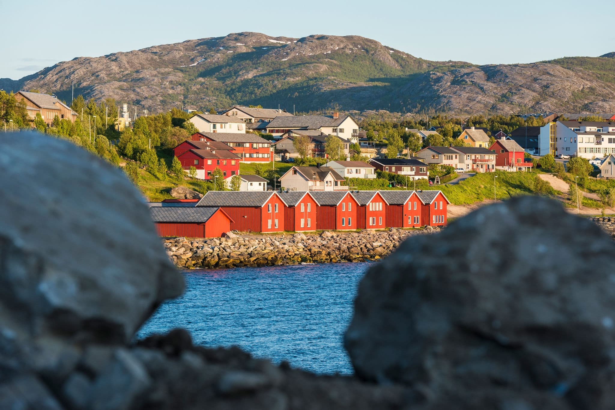 Red houses facades reflecting on the bay of Alta, Norway
