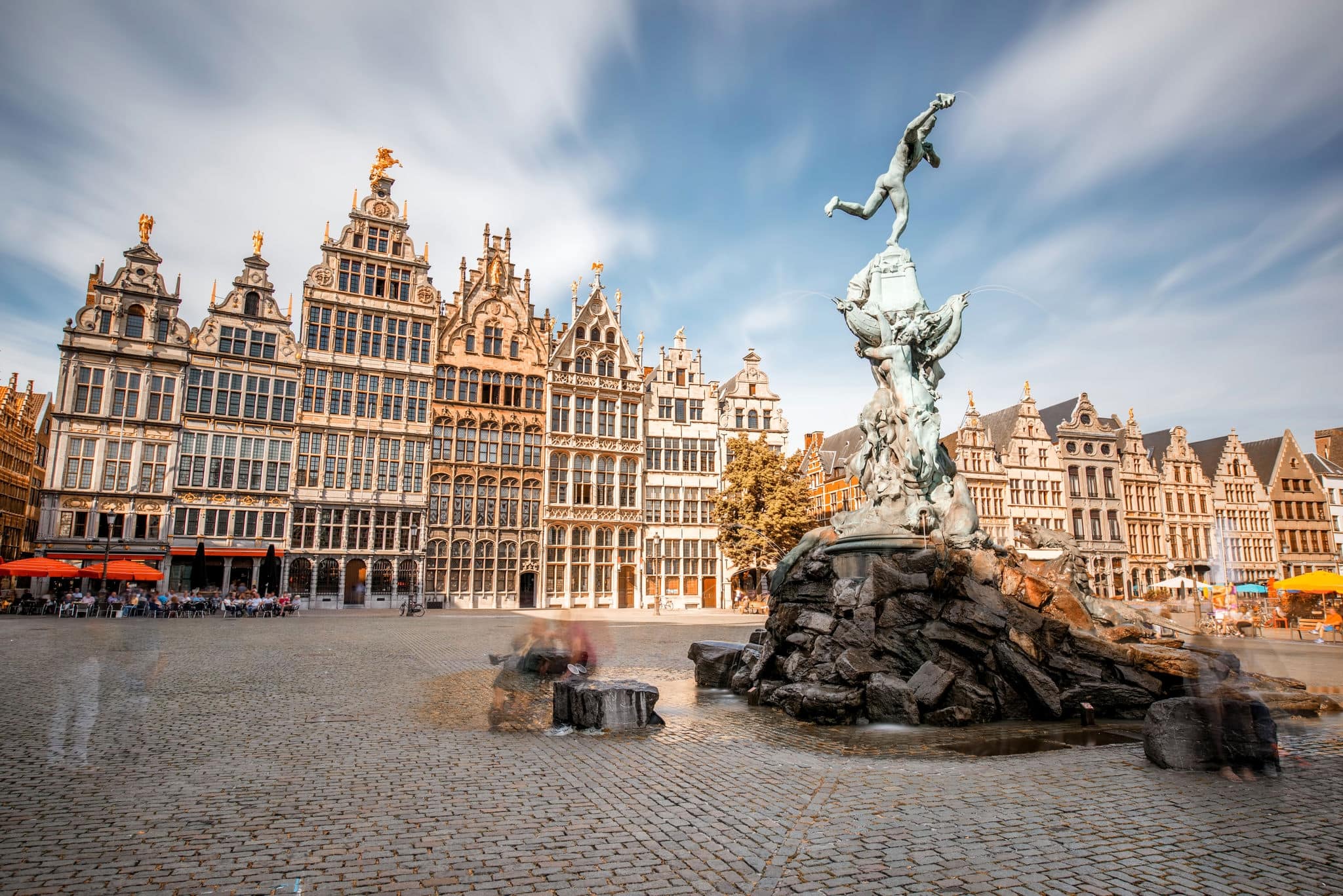Wide angle view on the Grote Markt square with Brabo fountain in Atwerpen city, Belgium. Long exposure image technic with motion blurred people and clouds