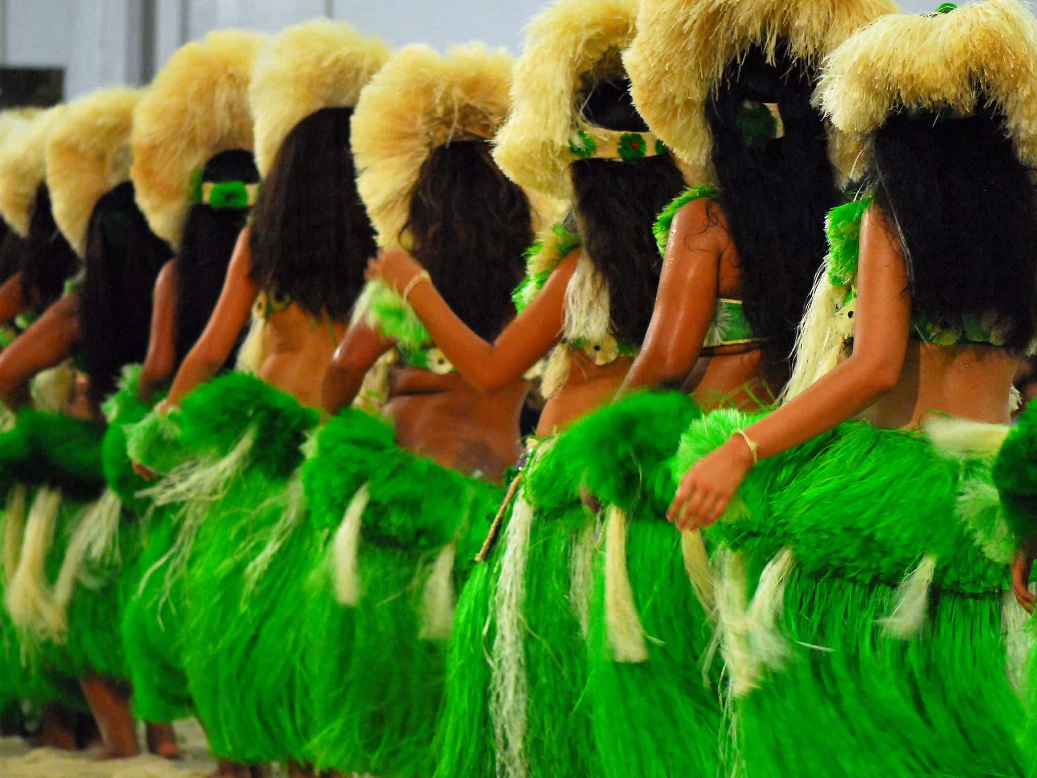 Group of Polynesian dancers in traditional green dresses performing in Raiatea, French Polynesia