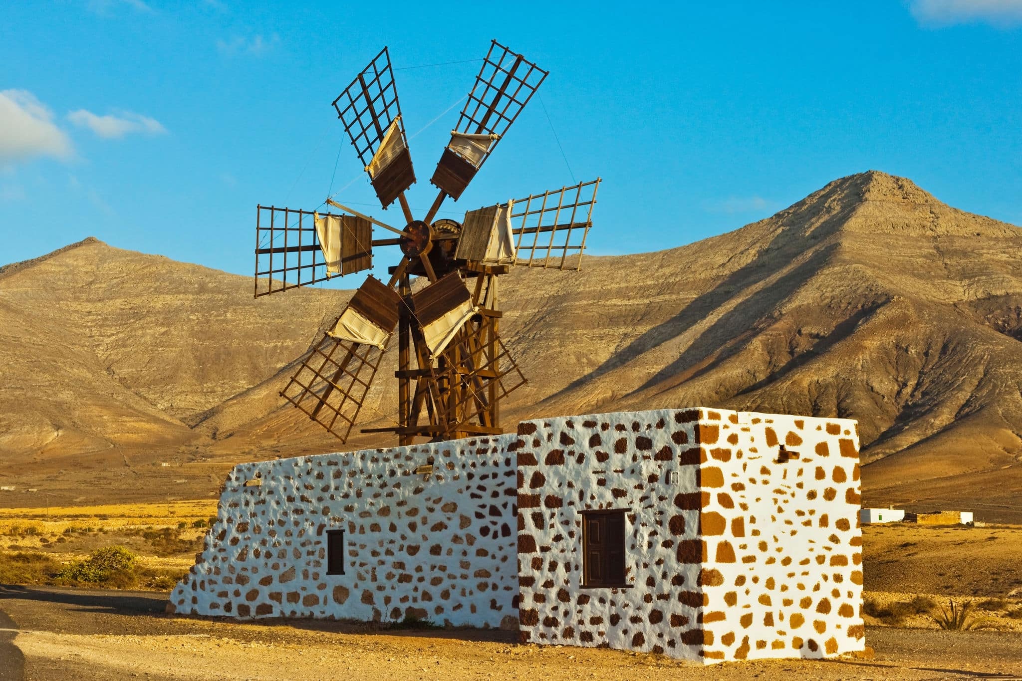 Windmill in the central valley and the 625m high churillos mountain beyond, tefia, puerto del rosario, fuerteventura, canary islands, spain, europe