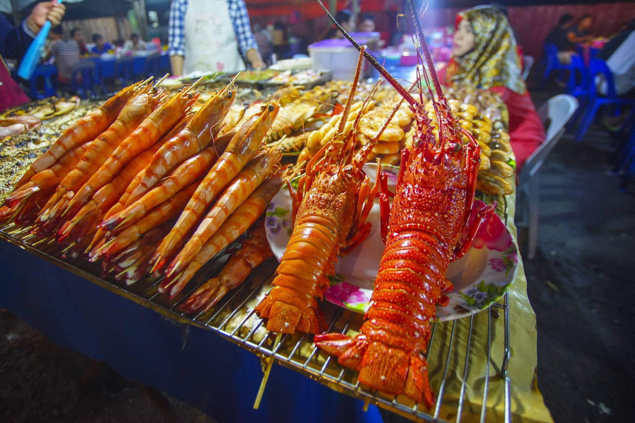 Variety of grilled seafood in Kota Kinabalu night market in Kota Kinabalu, Sabah Borneo, Malaysia. Selective focus, shallow DOF