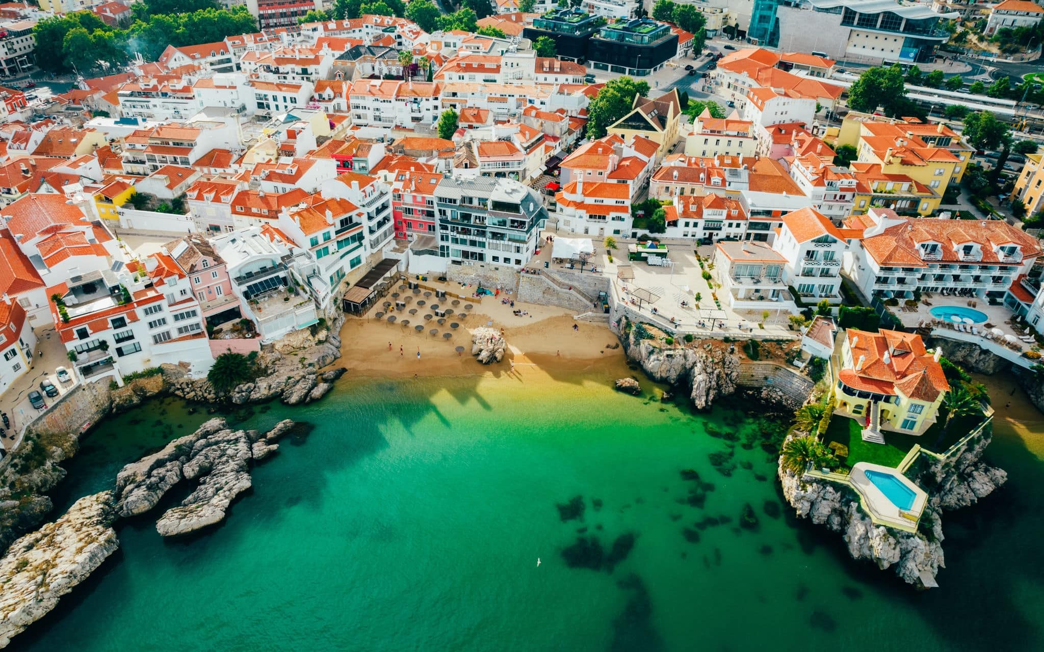 Drone aerial view of Praia da Rainha and historic city centre of Cascais, Portugal