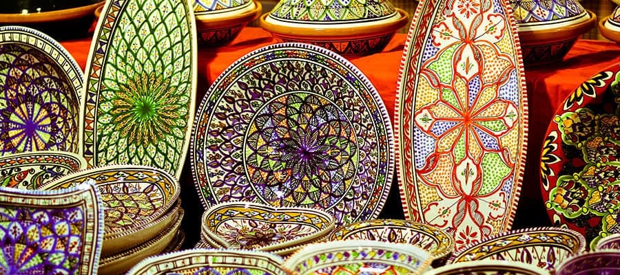 Artisan decorated plates displayed on market table in Port Said, Egypt.